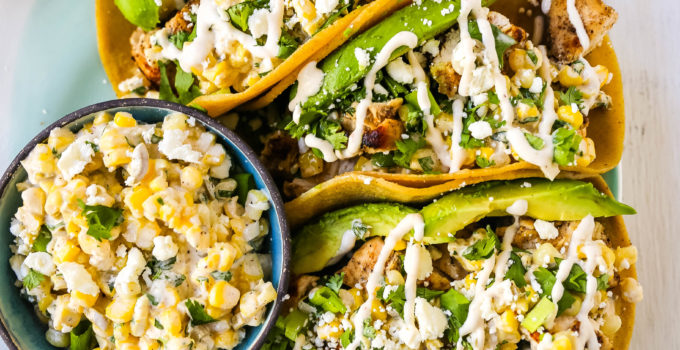 Mexican Street Corn Chicken Tacos Marinated grilled chicken with a homemade street corn salsa, fresh avocado, cotija cheese, and spiced Mexican crema. These tacos will become a family favorite in no time at all! www.modernhoney.com #taco #tacos #mexicanfood #chickentacos