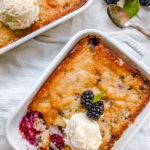 Blackberry Cobbler. A Texas favorite! This Blackberry Cobbler is made with a sweet, buttery crust with fresh sweetened blackberries and topped with vanilla bean ice cream. The perfect summer dessert recipe!