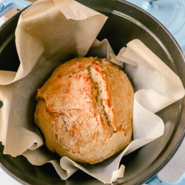 This No Knead Bread is baked in a dutch oven and is the perfect crusty french bread recipe. This makes a beautiful artisan loaf of bread and is so easy! The only ingredients you need are flour, water, salt, and yeast for the perfect overnight bread.