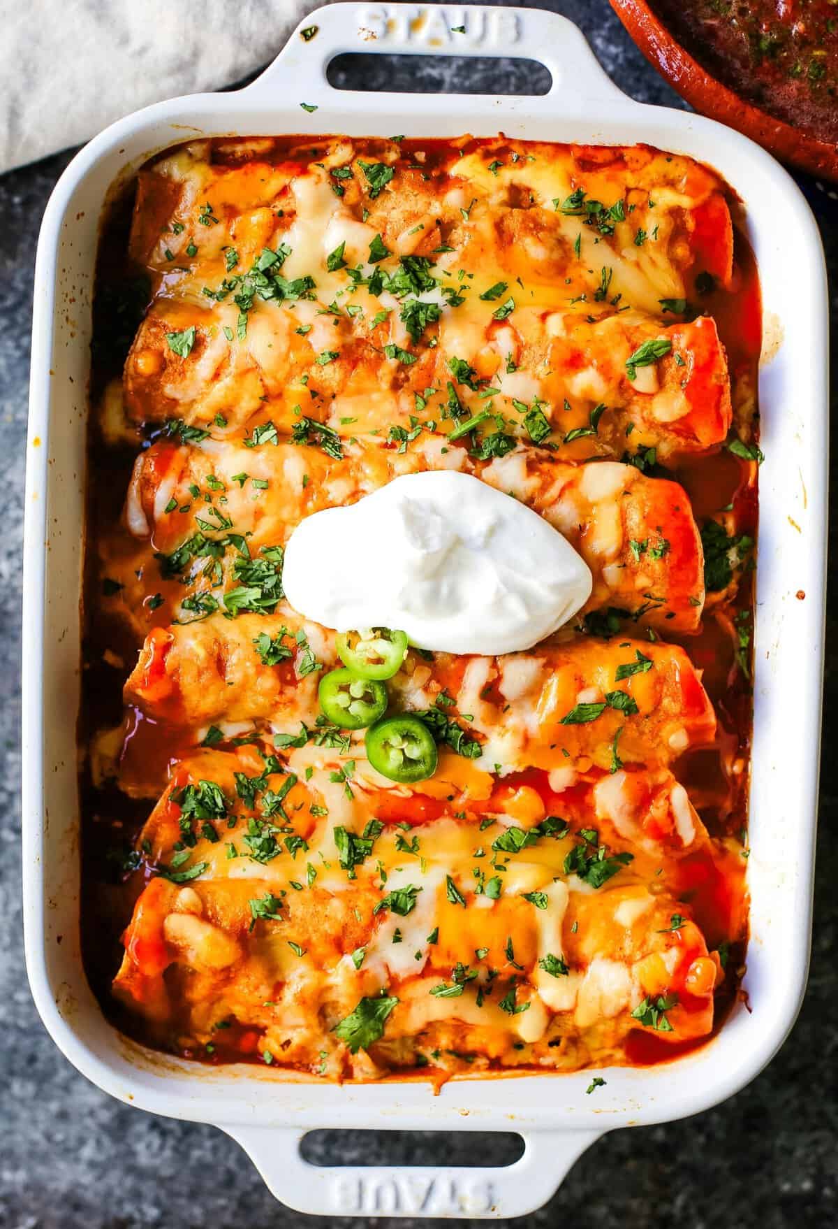 How to make Quick and Easy Chicken Enchiladas with only a few ingredients. This delicious chicken enchiladas recipe is super simple and a crowd pleaser.