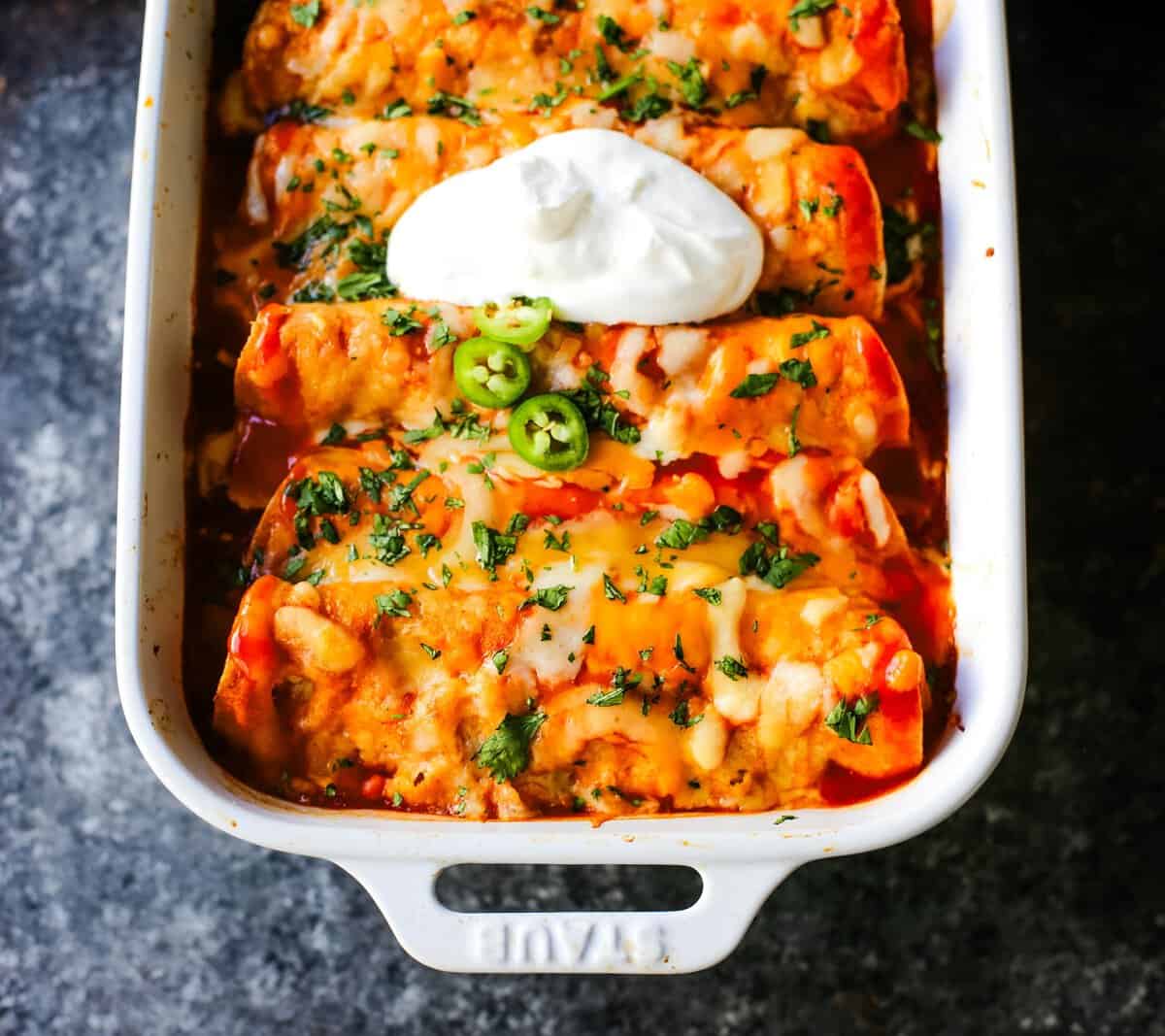 How to make Quick and Easy Chicken Enchiladas with only a few ingredients. This delicious chicken enchiladas recipe is super simple and a crowd pleaser.