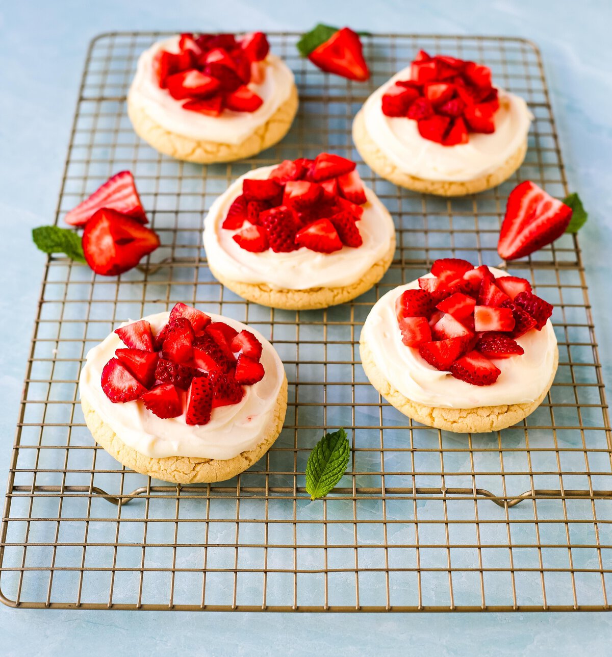 These Frosted Strawberries and Cream Cookies are soft, buttery sugar cookies topped with velvety smooth, sweet cream cheese frosting and topped with fresh strawberries. The perfect frosted strawberry cookie recipe!