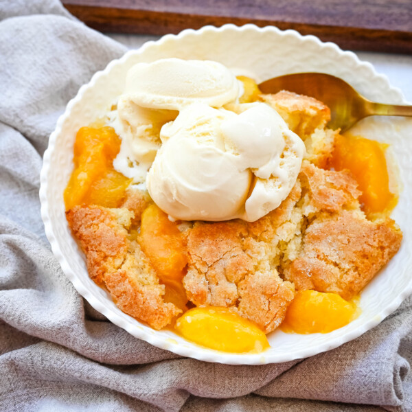 This Homemade Nectarine Cobbler is made with fresh nectarines tossed in sugar and topped with a golden, buttery crust and served warm with vanilla bean ice cream. This is the best nectarine cobbler recipe!
