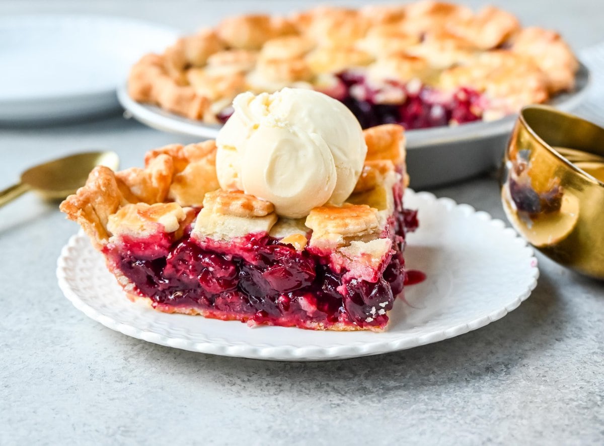 Homemade cherry pie is bursting with sweet-tart cherries nestled in a flaky, golden crust and topped with vanilla bean ice cream. I am sharing tips and tricks for making sweet cherry pie at home.