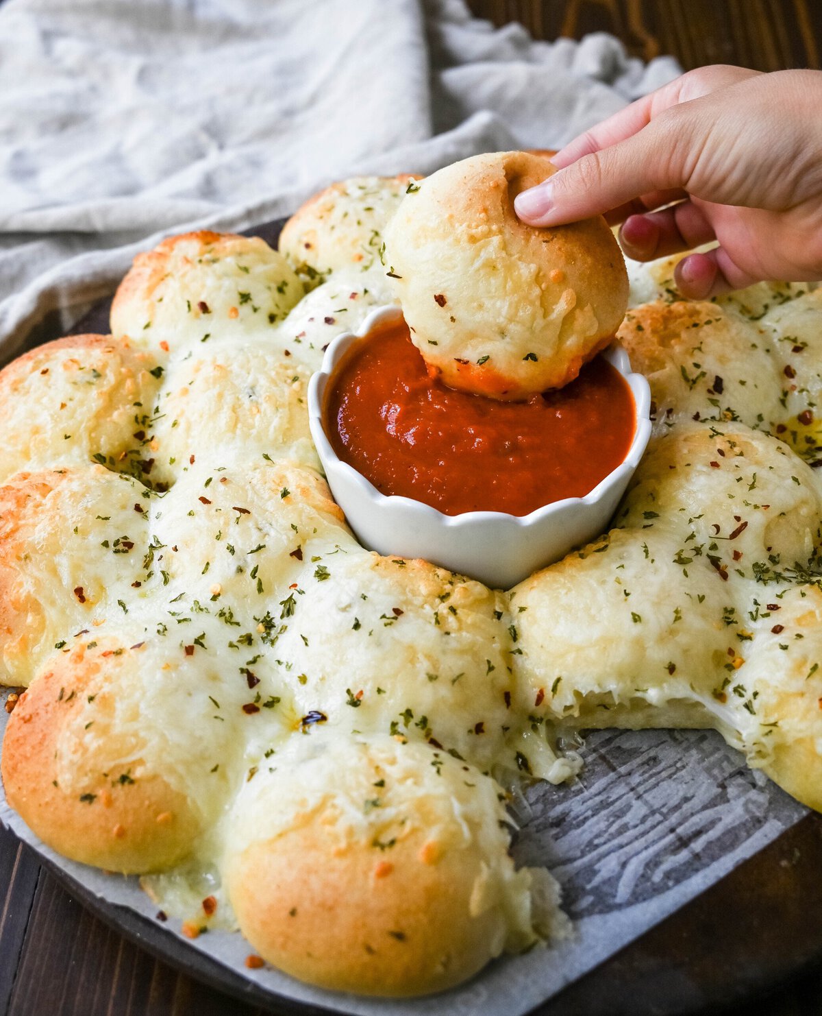 Cheesy garlic monkey bread, or garlic cheese pull-apart bread, made with Rhodes frozen dinner rolls, is soft, buttery, and cheesy. Each roll is dipped in garlic butter and then topped with gooey, melted mozzarella cheese that bubbles as it bakes. The result is a pull-apart bread that's golden on the outside, fluffy on the inside, and has cheesy, garlicky goodness in every bite. 