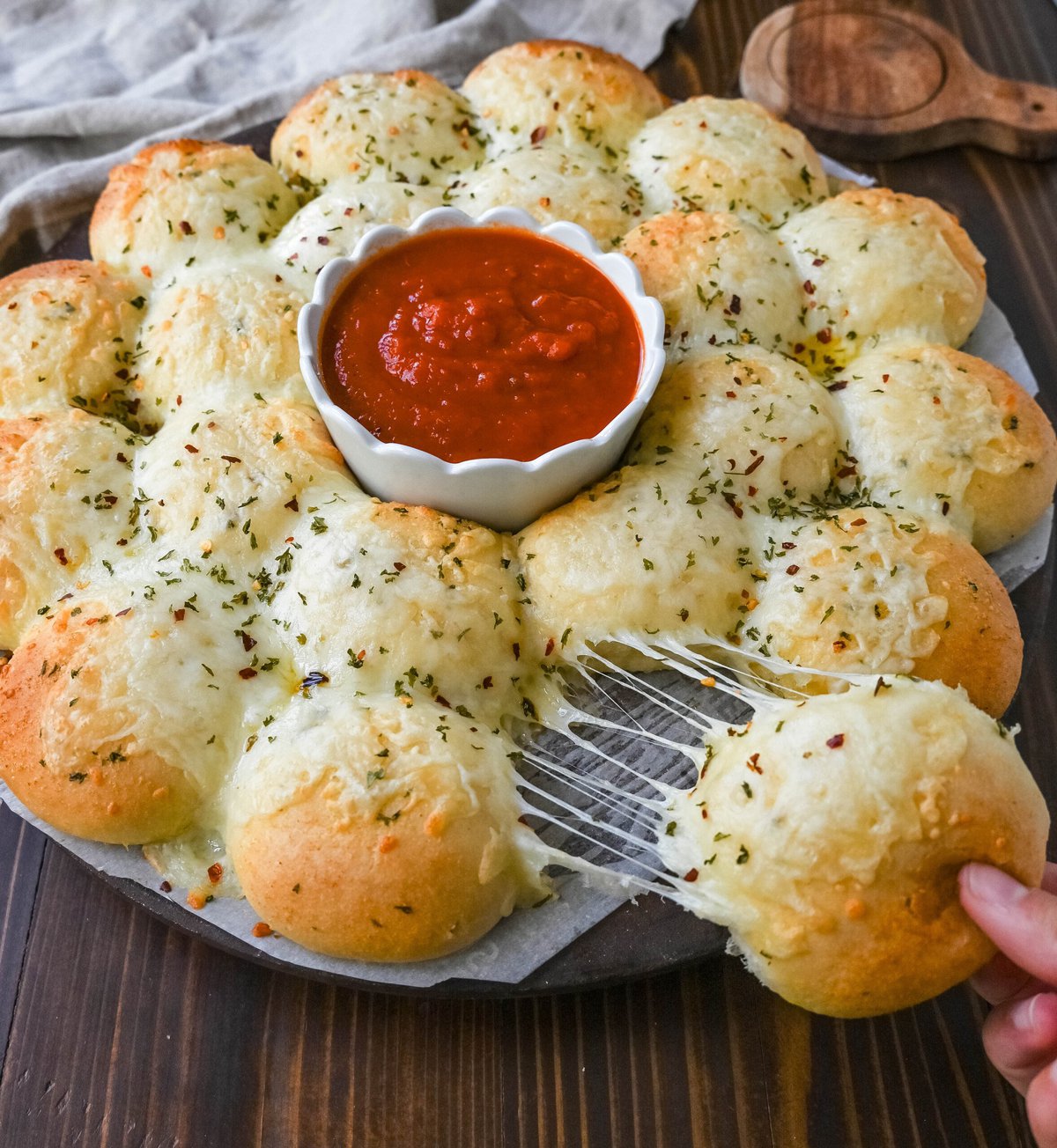 Cheesy garlic monkey bread, or garlic cheese pull-apart bread, made with Rhodes frozen dinner rolls, is soft, buttery, and cheesy. Each roll is dipped in garlic butter and then topped with gooey, melted mozzarella cheese that bubbles as it bakes. The result is a pull-apart bread that's golden on the outside, fluffy on the inside, and has cheesy, garlicky goodness in every bite. 