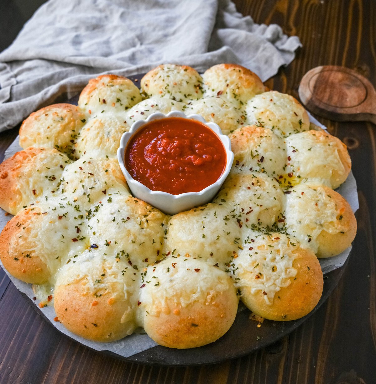 Cheesy garlic monkey bread, or garlic cheese pull-apart bread, made with Rhodes frozen dinner rolls, is soft, buttery, and cheesy. Each roll is dipped in garlic butter and then topped with gooey, melted mozzarella cheese that bubbles as it bakes. The result is a pull-apart bread that's golden on the outside, fluffy on the inside, and has cheesy, garlicky goodness in every bite. 