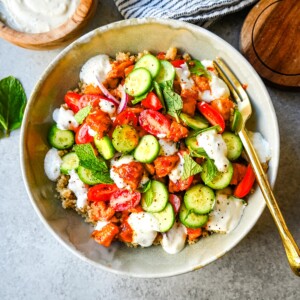 Mediterranean Chicken Bowls are made with sweet and spicy harissa honey chicken, fluffy quinoa, a Greek salad, and creamy tzatziki sauce. It is a spicy, sweet, crunchy, and creamy, healthy chicken bowl.