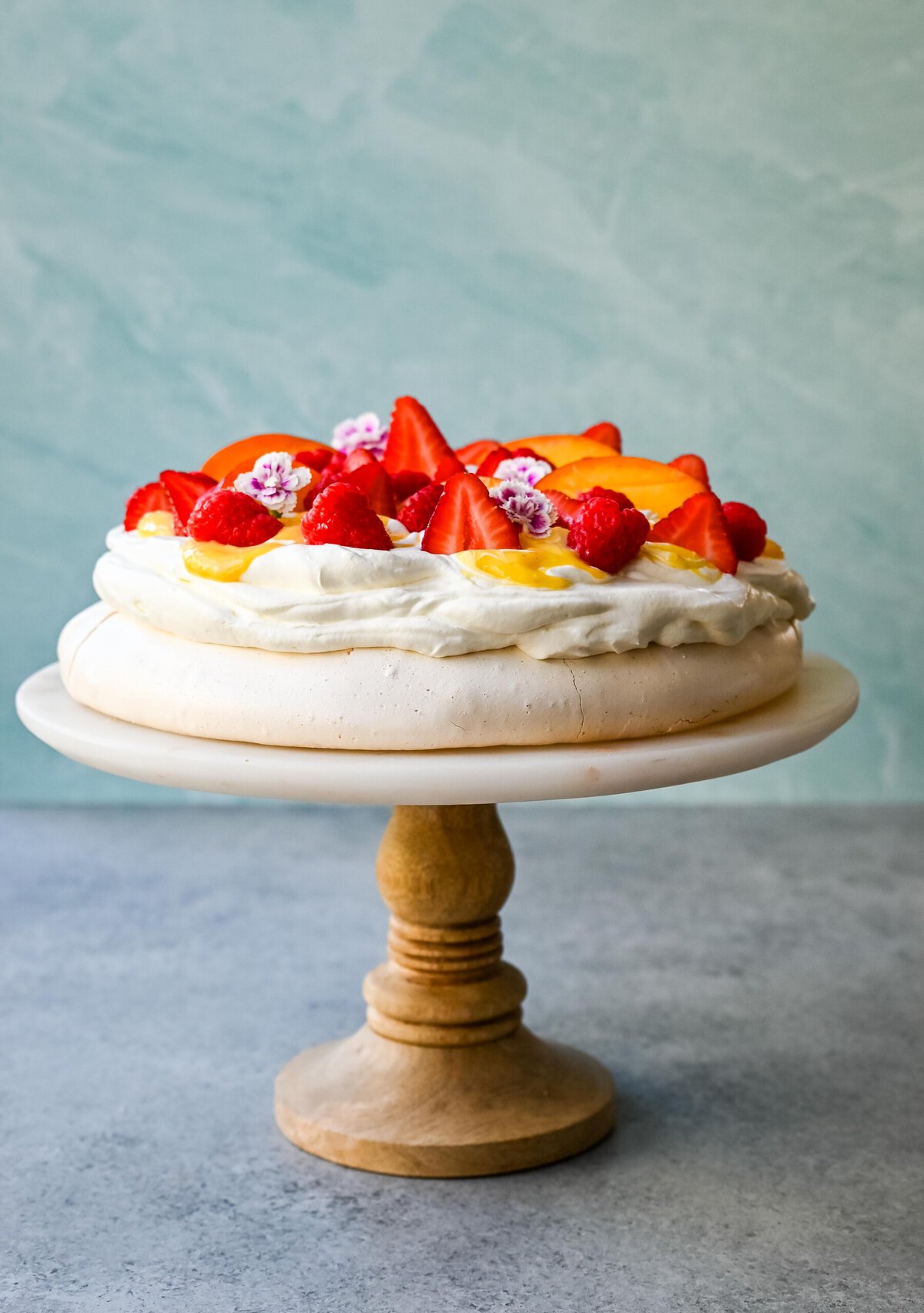 Pavlova is a stunning and elegant dessert with a crisp, crunchy outer shell with a soft, marshmallow-like center and topped with fresh whipped cream and fresh fruit. This homemade pavlova is a beautiful and delicious dessert.