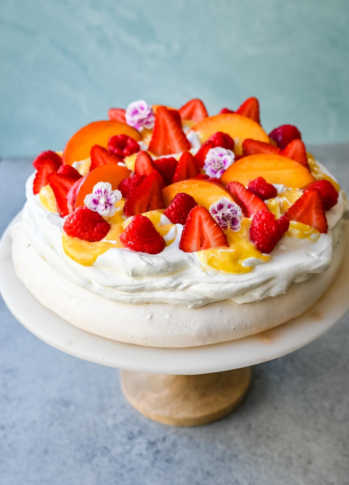 Pavlova is a stunning and elegant dessert with a crisp, crunchy outer shell with a soft, marshmallow-like center and topped with fresh whipped cream and fresh fruit. This homemade pavlova is a beautiful and delicious dessert.