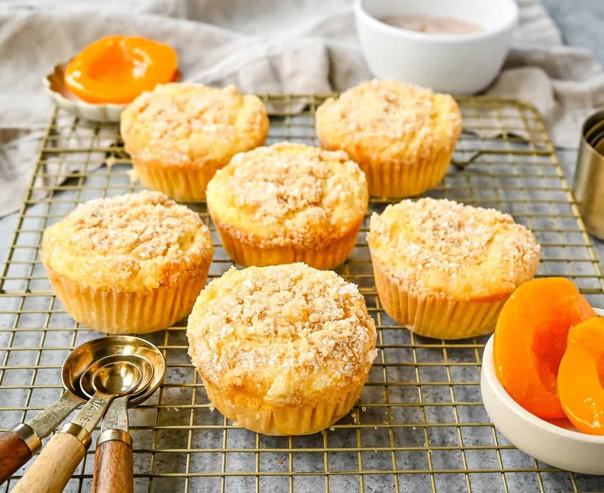 These Peach Cobbler Muffins are made with fresh, juicy peaches topped with a buttery streusel topping. These peach muffins are tender, moist, and bursting with fresh peach flavor and the sweetness of white chocolate chips.