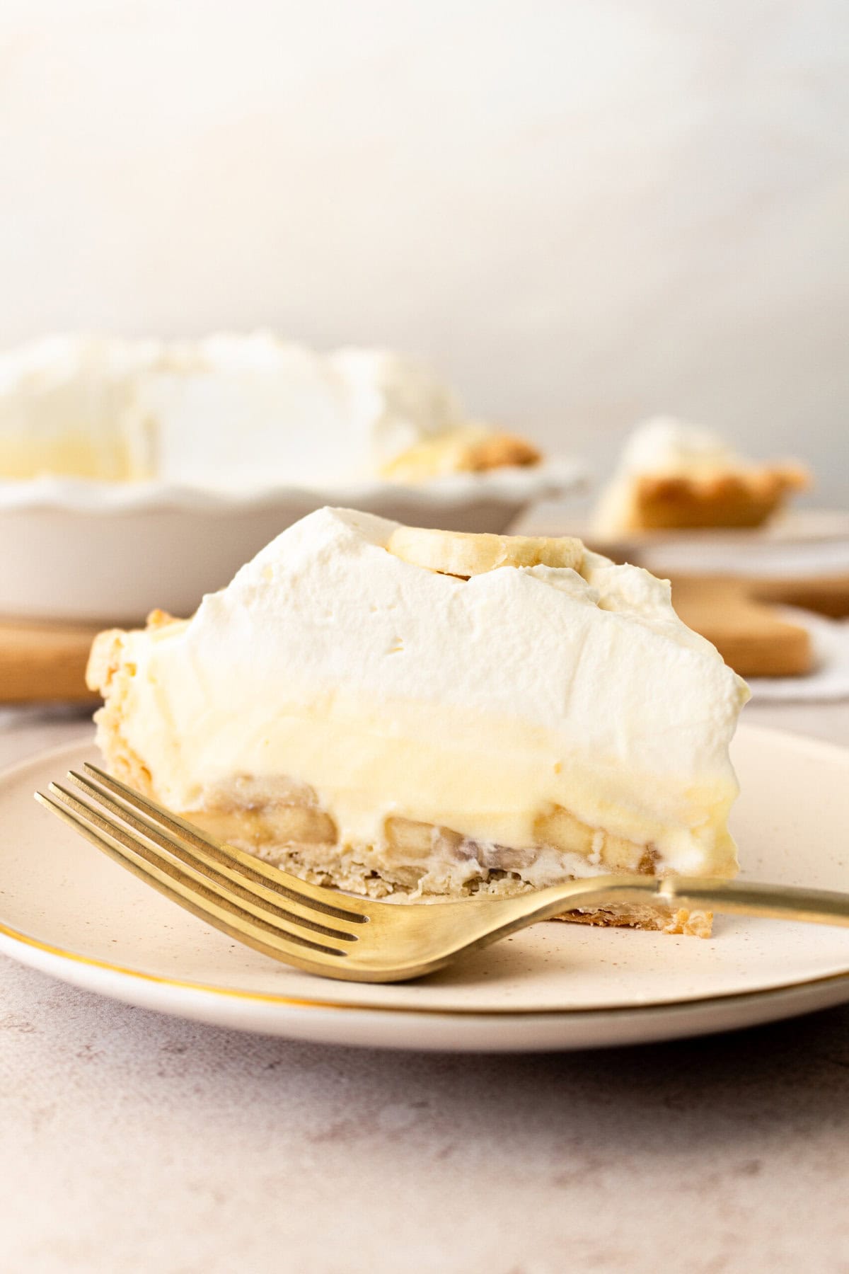 A slice of homemade banana cream pie. This easy banana cream pie recipe is made with vanilla instant pudding mix, sweetened condensed milk, fresh bananas, and fresh whipped cream.