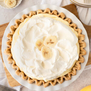 Indulge in the sweet and creamy goodness of this classic dessert. This Banana Cream Pie Recipe is made with a buttery crust, smooth vanilla custard, fresh bananas, and topped with fluffy whipped cream. This easy banana cream pie is sure to satisfy any sweet tooth.