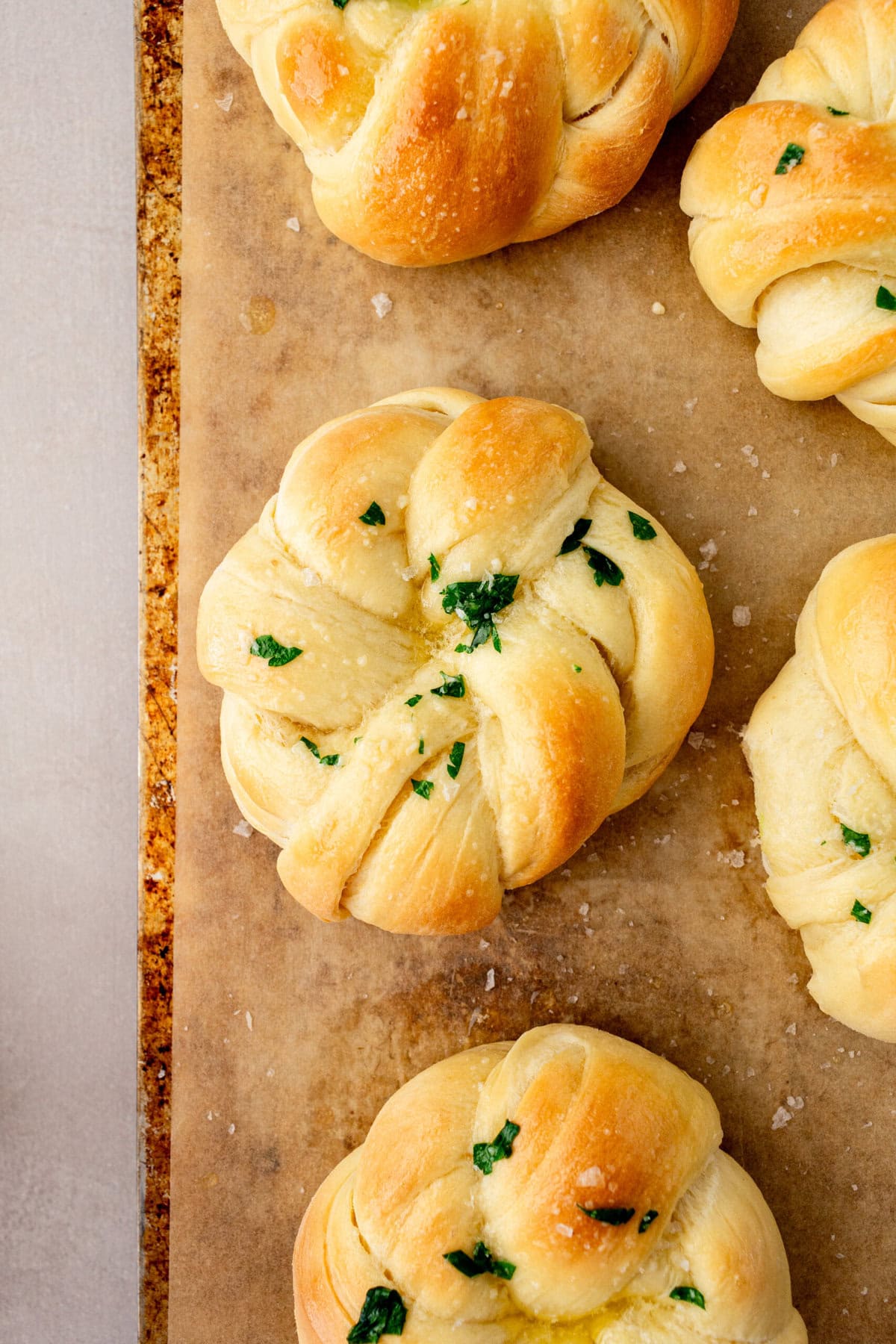 Knotted Rolls baked in the oven on baking sheet and brushed with garlic butter.