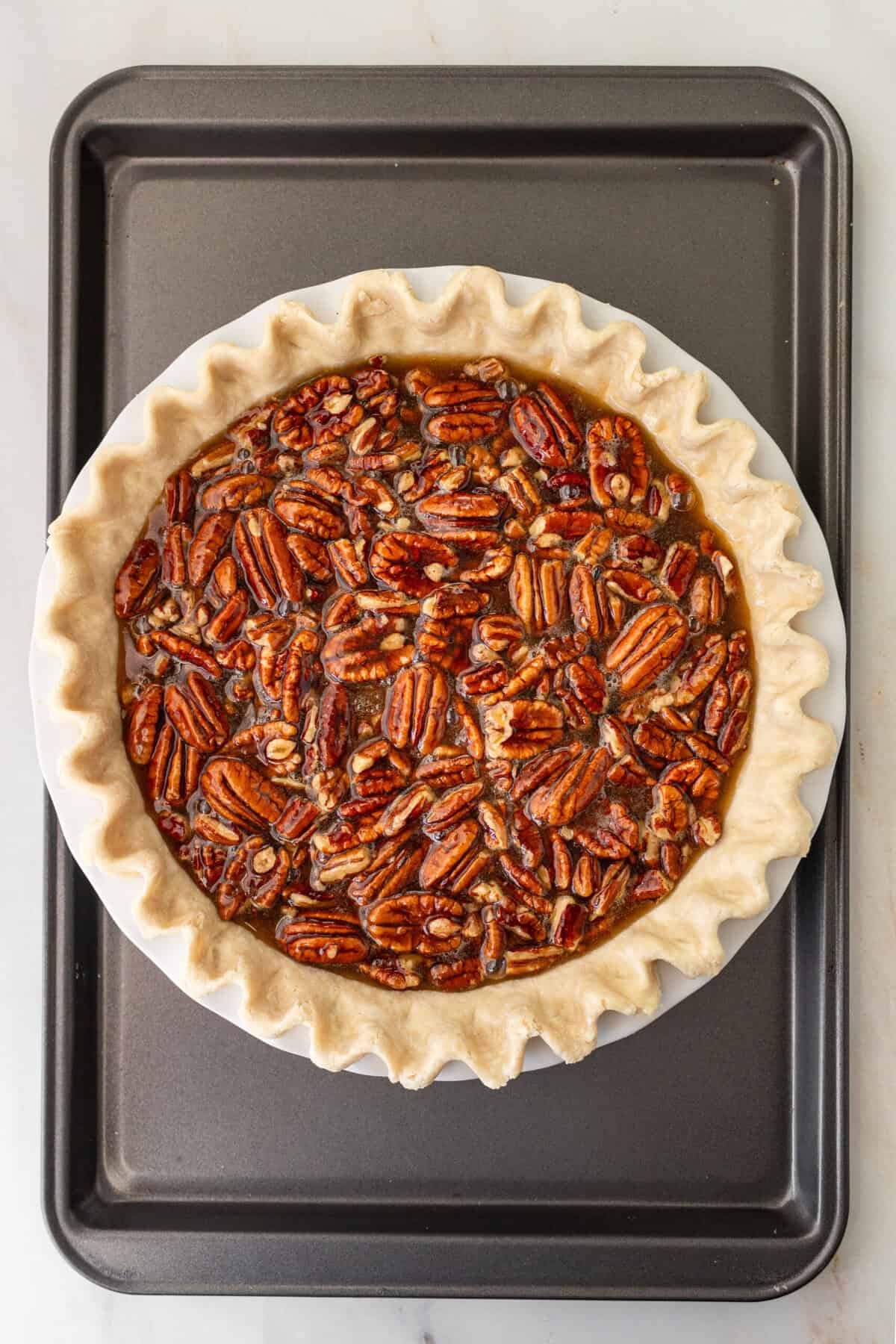 Homemade pecan pie filling in a pie crust before baking