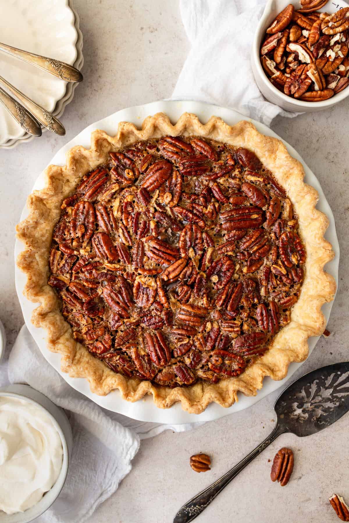 This is the best pecan pie recipe made with a rich, gooey filling with the crunchy, nutty goodness of toasted pecans. It pairs perfectly with a homemade buttery, flaky pie crust. The filling is a sweet blend of brown sugar, eggs, and vanilla, which creates a silky texture that melts in your mouth. You will love this easy pecan pie recipe!