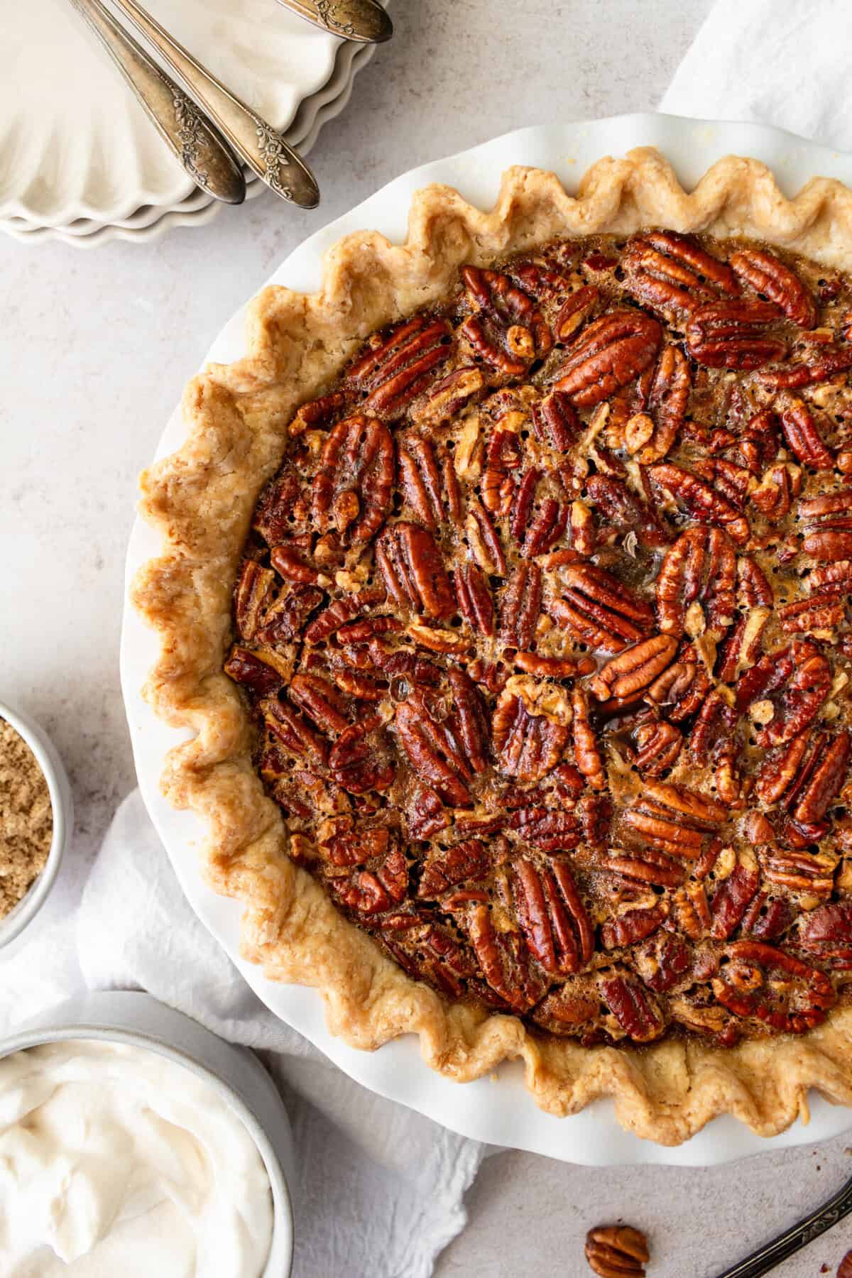 This is the best pecan pie recipe made with a rich, gooey filling with the crunchy, nutty goodness of toasted pecans. It pairs perfectly with a homemade buttery, flaky pie crust. The filling is a sweet blend of brown sugar, eggs, and vanilla, which creates a silky texture that melts in your mouth. You will love this easy pecan pie recipe!