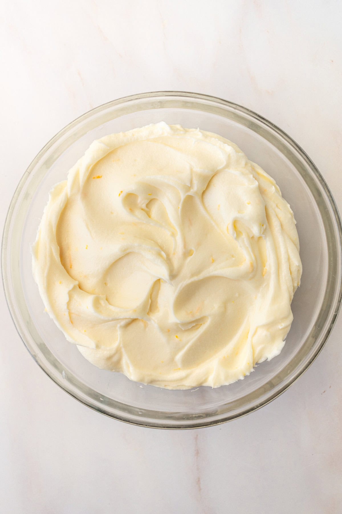 Orange cream cheese frosting to frost a homemade orange cake.