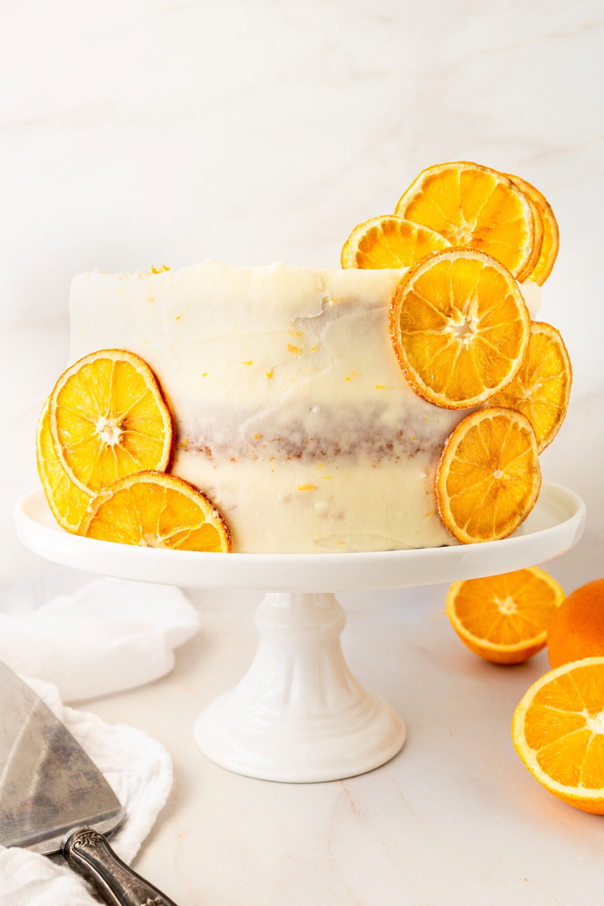 A moist, tender fresh orange cake with a sweet orange cream cheese frosting. This homemade orange cake that is bursting with bright citrus flavor in every bite. Each layer is moist, fluffy, and perfectly enhanced by an orange cream cheese frosting. The fresh orange juice and zest adds fresh orange flavor.  Here are tips for making the perfect frosted orange cake! This can also be made into an orange naked cake.