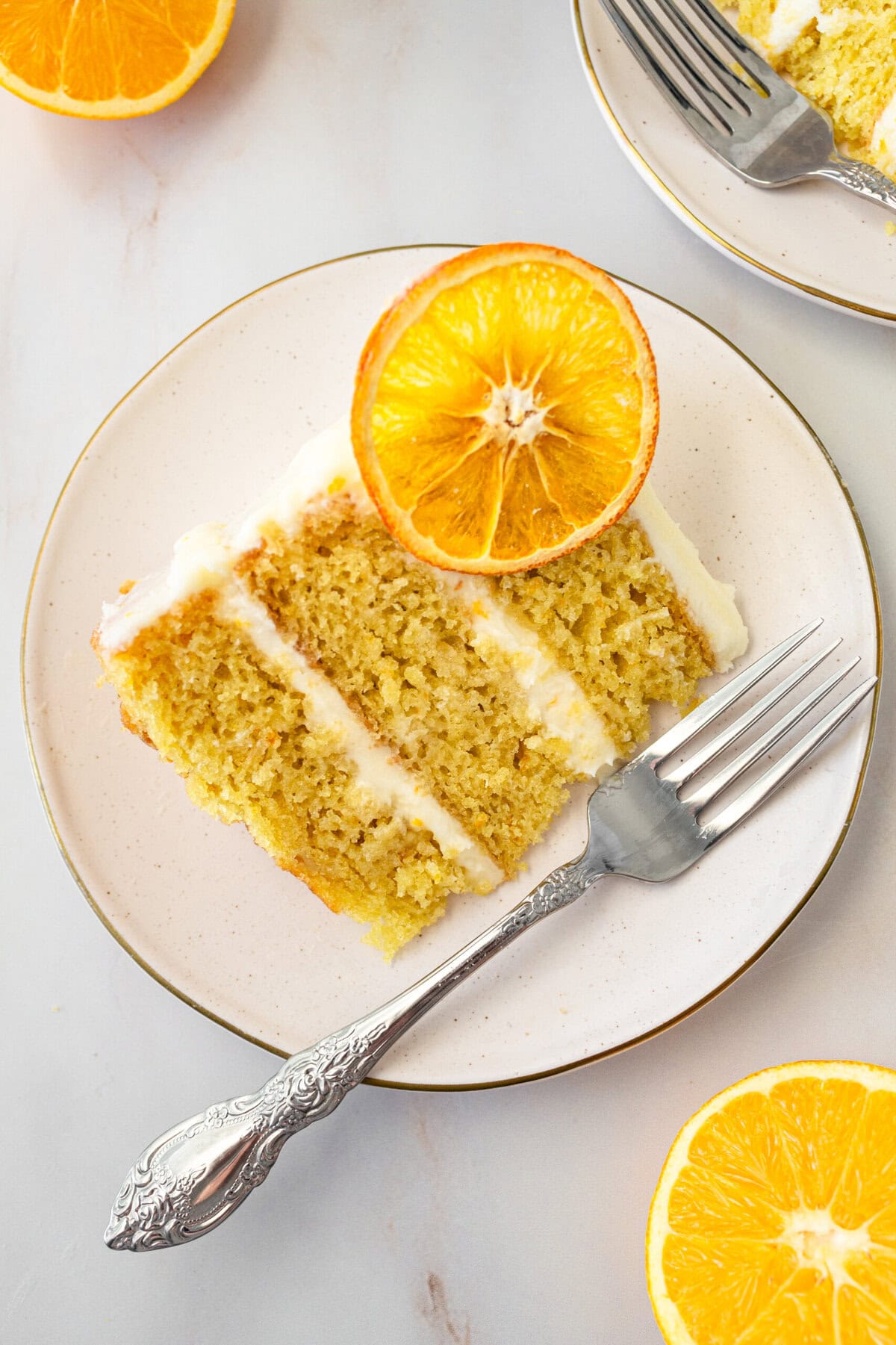 A moist, tender fresh orange cake with a sweet orange cream cheese frosting. This homemade orange cake that is bursting with bright citrus flavor in every bite. Each layer is moist, fluffy, and perfectly enhanced by an orange cream cheese frosting. The fresh orange juice and zest adds fresh orange flavor.  Here are tips for making the perfect frosted orange cake! This can also be made into an orange naked cake.