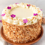 This homemade, moist coconut cake with coconut cream cheese frosting is the best coconut cake recipe. It is made with sweet cream butter, coconut milk, buttermilk, coconut pudding mix, and cake flour to make it extra tender. The coconut cream cheese frosting puts it over the top!