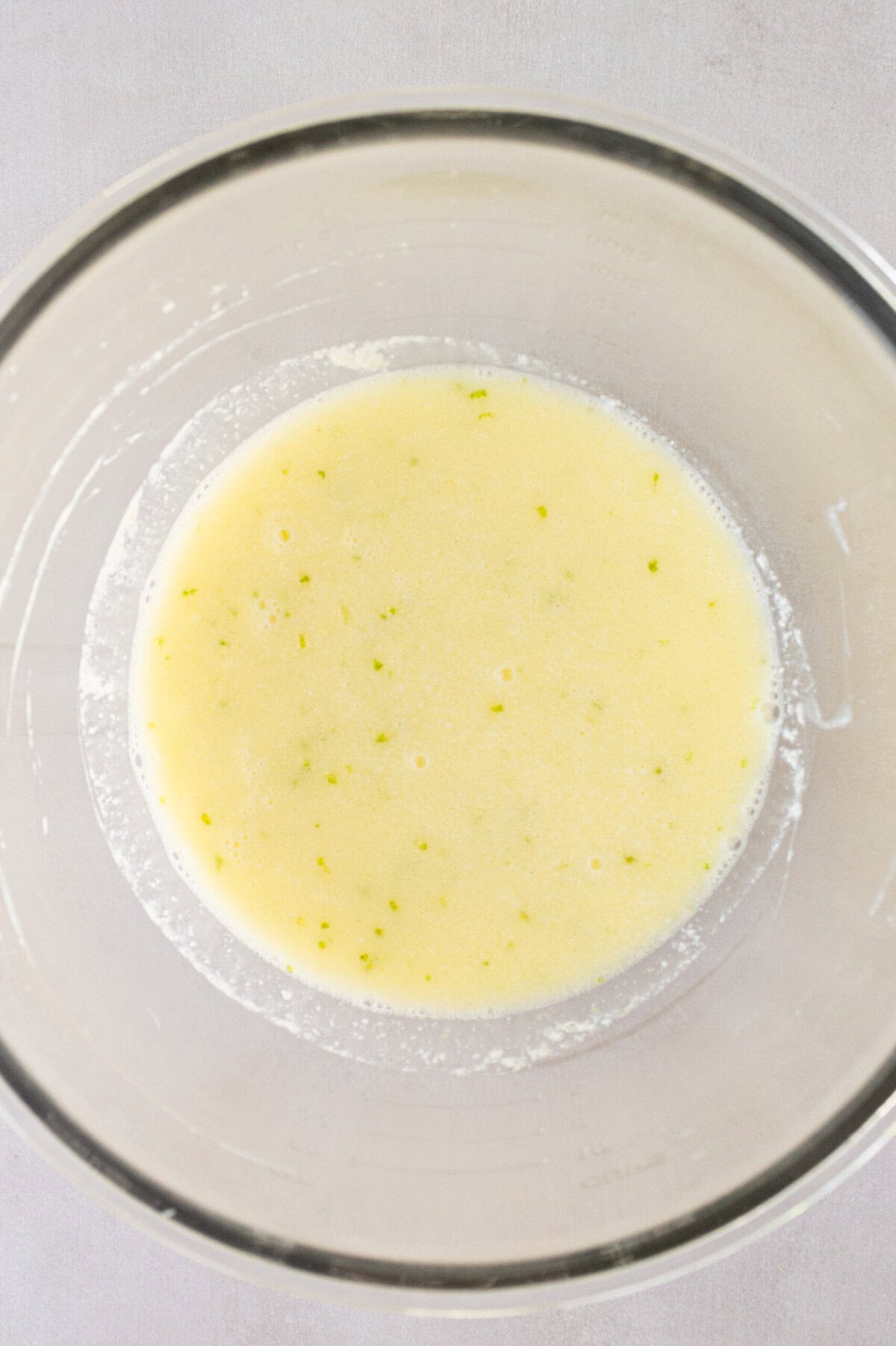 Making a homemade key lime cake batter with fresh ingredients.