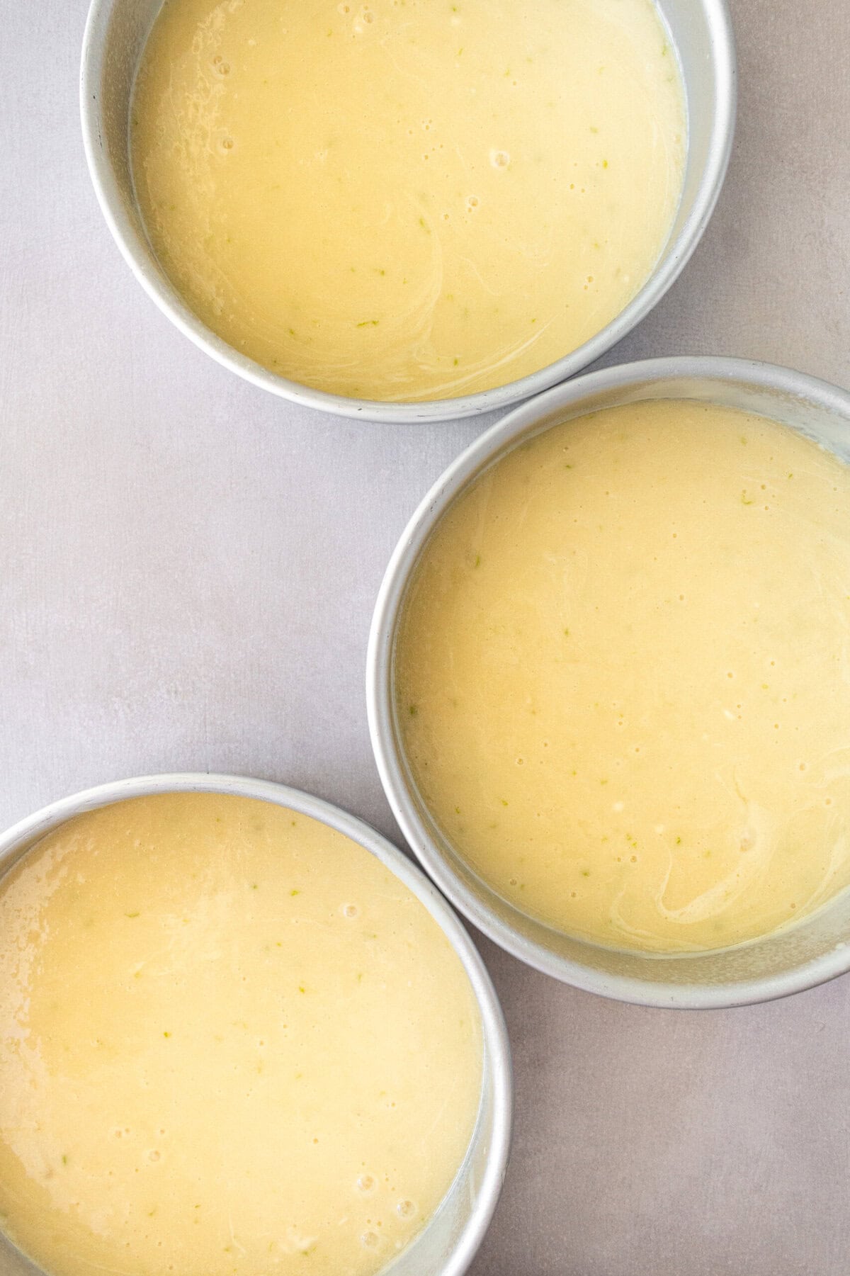 Pour key lime cake batter into three 8-inch cake pans before baking.