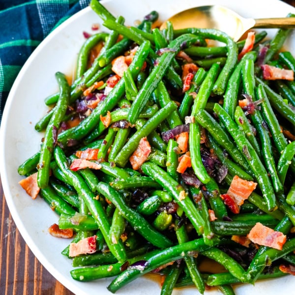 This recipe for brown sugar bacon green beans brings a sweet and savory twist to traditional green beans with the addition of crispy bacon, caramelized onions, and a buttery brown sugar glaze. This easy side dish is perfect for holiday dinners, Thanksgiving or as crowd pleasing side dish, adding just the right amount of richness to fresh green beans while keeping them fresh and crisp-tender.