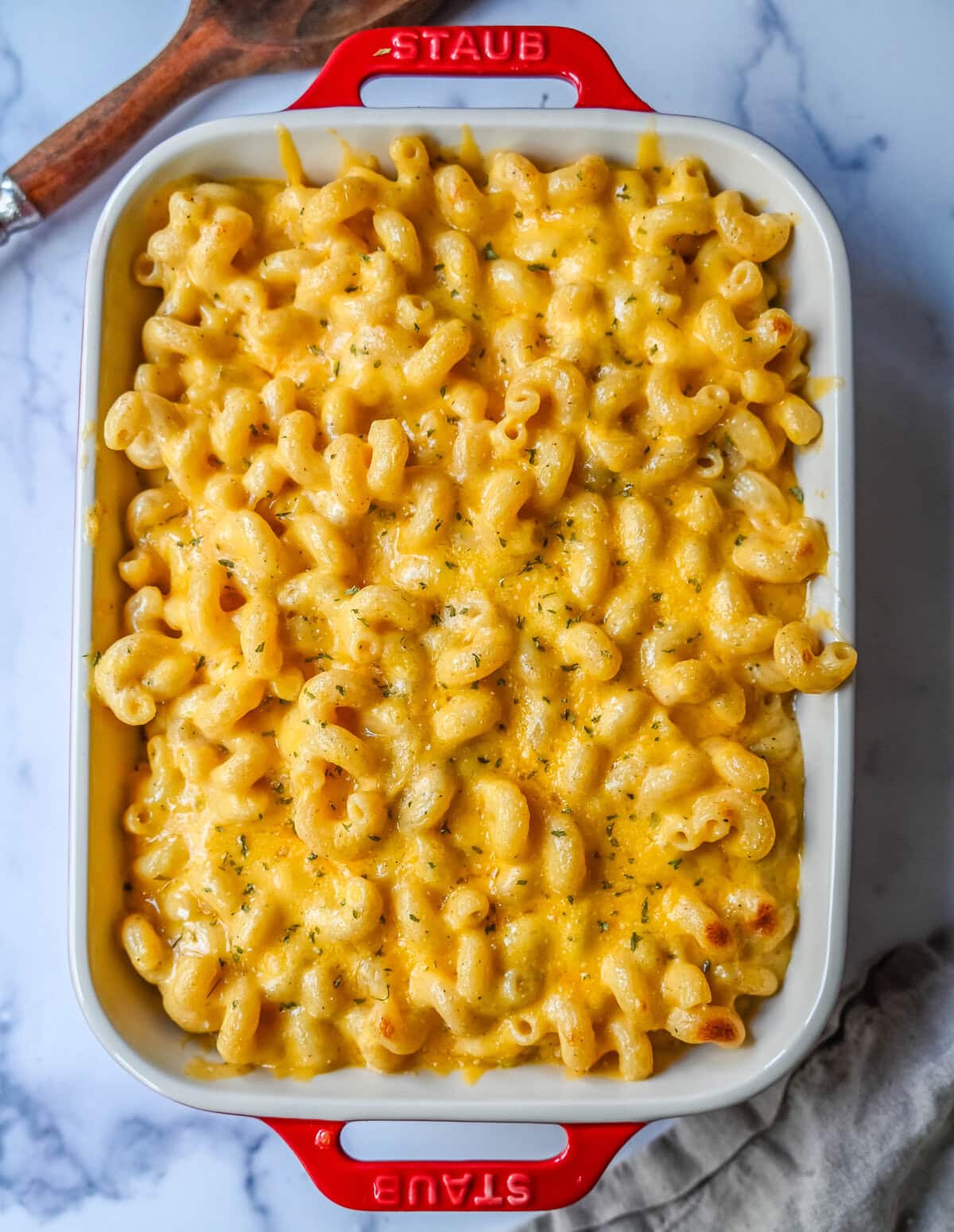 A baking dish of easy homemade mac and cheese. How to make a quick, easy, creamy, cheesy homemade mac and cheese recipe. All of the tips and tricks for making a velvety cheese sauce that is completely smooth. You will love this easy mac and cheese recipe!