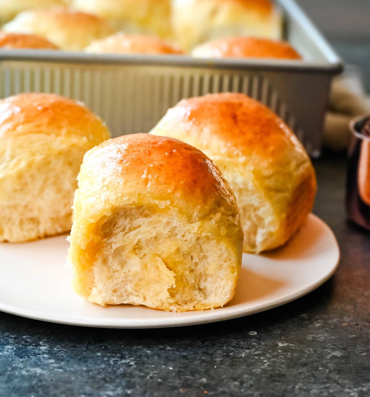 Homemade dinner roll on plate. These Japanese milk bread dinner rolls are the most soft, fluffy, and tender homemade rolls due to a special technique. This game changing technique makes all of the difference for making melt-in-your-mouth rolls.