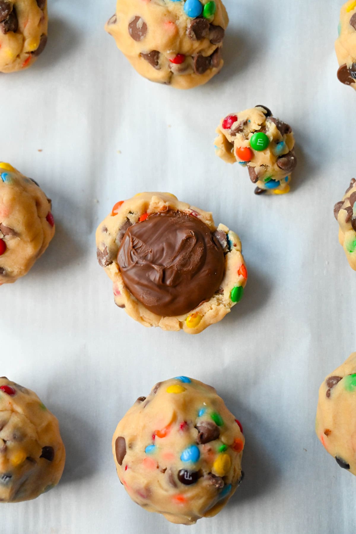 M&M Nutella Lava Cookie stuffed with Nutella. Freeze dollops of nutella before placing in the center of a cookie dough ball and wrap cookie dough around it.