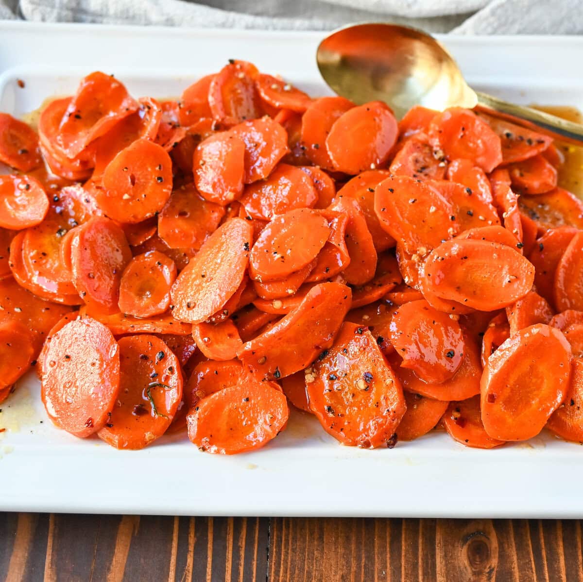 These Roasted Carrots with a Maple Brown Sugar Glaze are carrots roasted in butter, real maple syrup, brown sugar, and a touch of red pepper flakes. These maple glazed carrots are sweet and savory and a perfect side dish recipe.