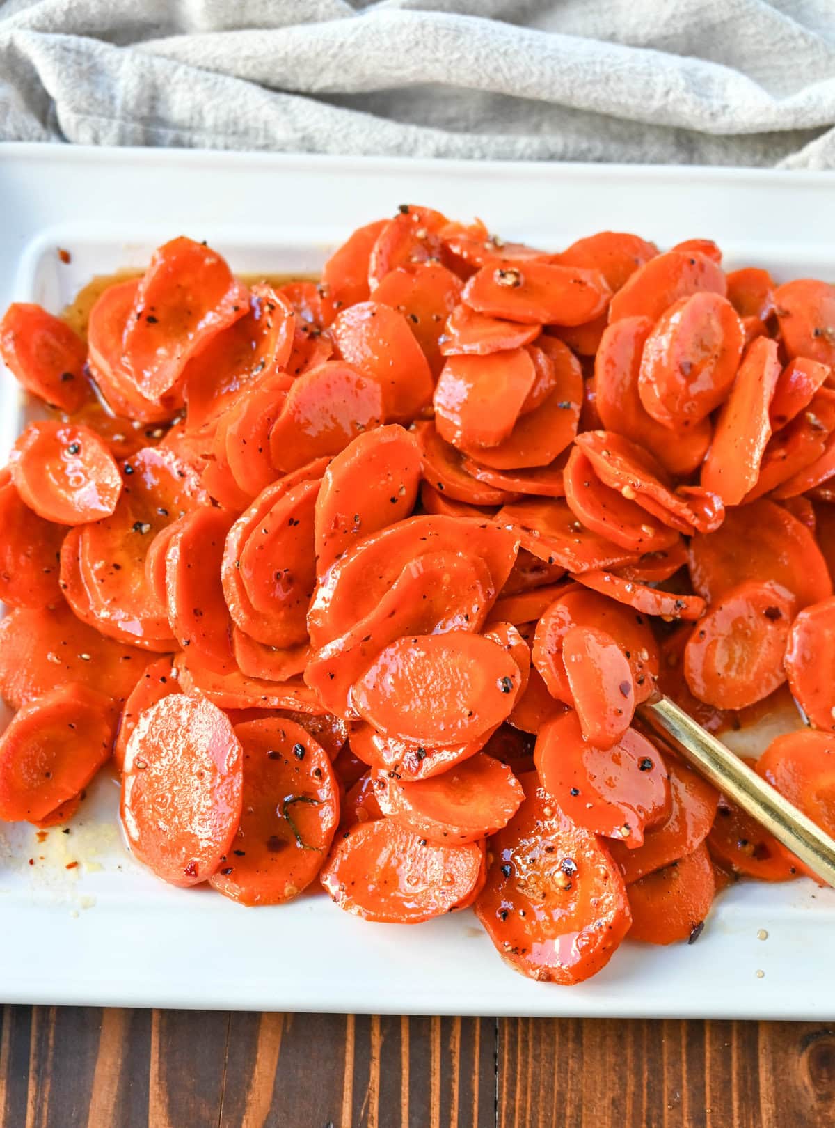 These Roasted Carrots with a Maple Brown Sugar Glaze are carrots roasted in butter, real maple syrup, brown sugar, and a touch of red pepper flakes. These maple glazed carrots are sweet and savory and a perfect side dish recipe.