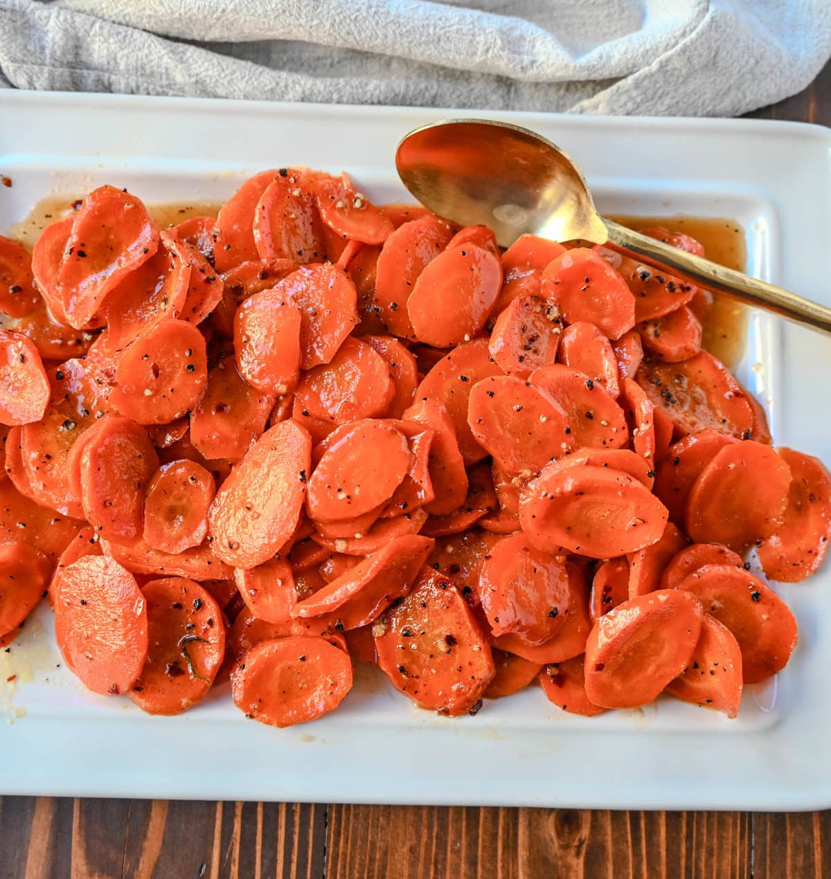 These Roasted Carrots with a Maple Brown Sugar Glaze are carrots roasted in butter, real maple syrup, brown sugar, and a touch of red pepper flakes. These maple glazed carrots are sweet and savory and a perfect side dish recipe.