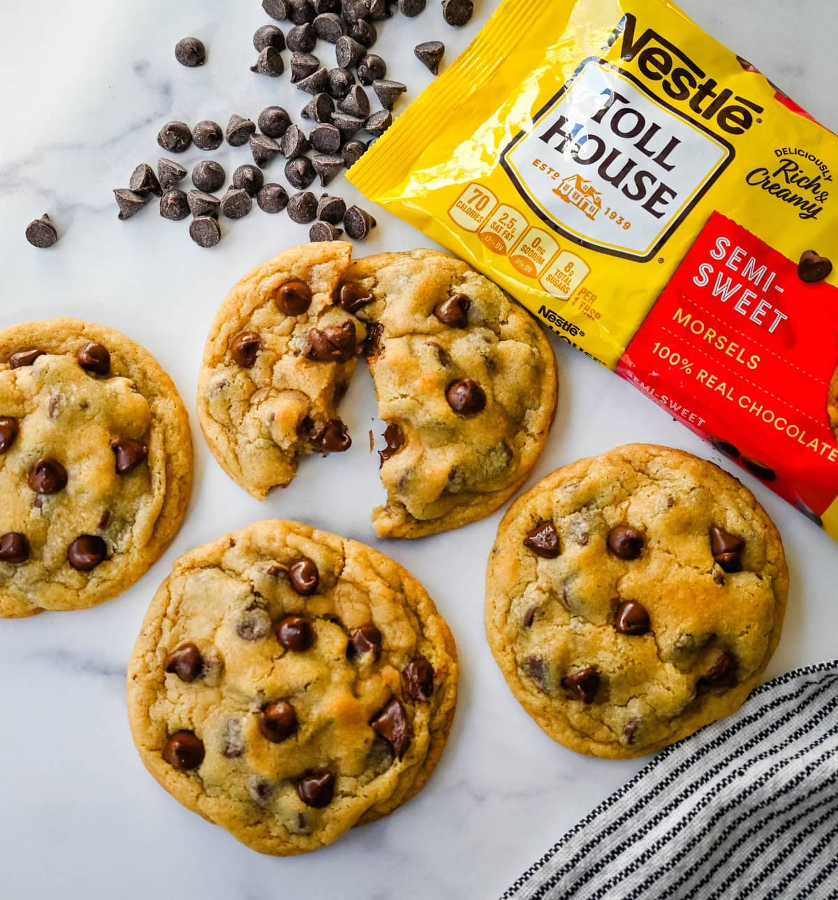 The Nestle Toll House Chocolate Chip Cookie Recipe. How to make the original Toll House chocolate chip cookie recipe on the bag. Tips for making the best Toll house chocolate chip cookies. Chocolate chip cookies on a plate with a yellow Nestle Toll House chocolate chips bag. Homemade chocolate chip cookies stacked on a plate made with Nestle toll house chocolate chips. Chocolate chip cookie torn into half to show the melted Nestle chocolate chips.