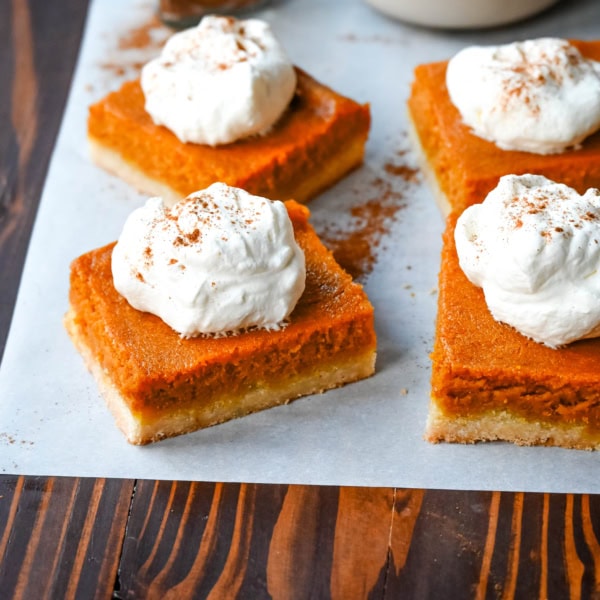 These homemade Pumpkin Pie Bars are made with a buttery shortbread crust and topped with a creamy pumpkin cream cheese filling and baked. These easy pumpkin pie bars are topped with fresh whipped cream and cut into squares for an easy alternative to pumpkin pie.