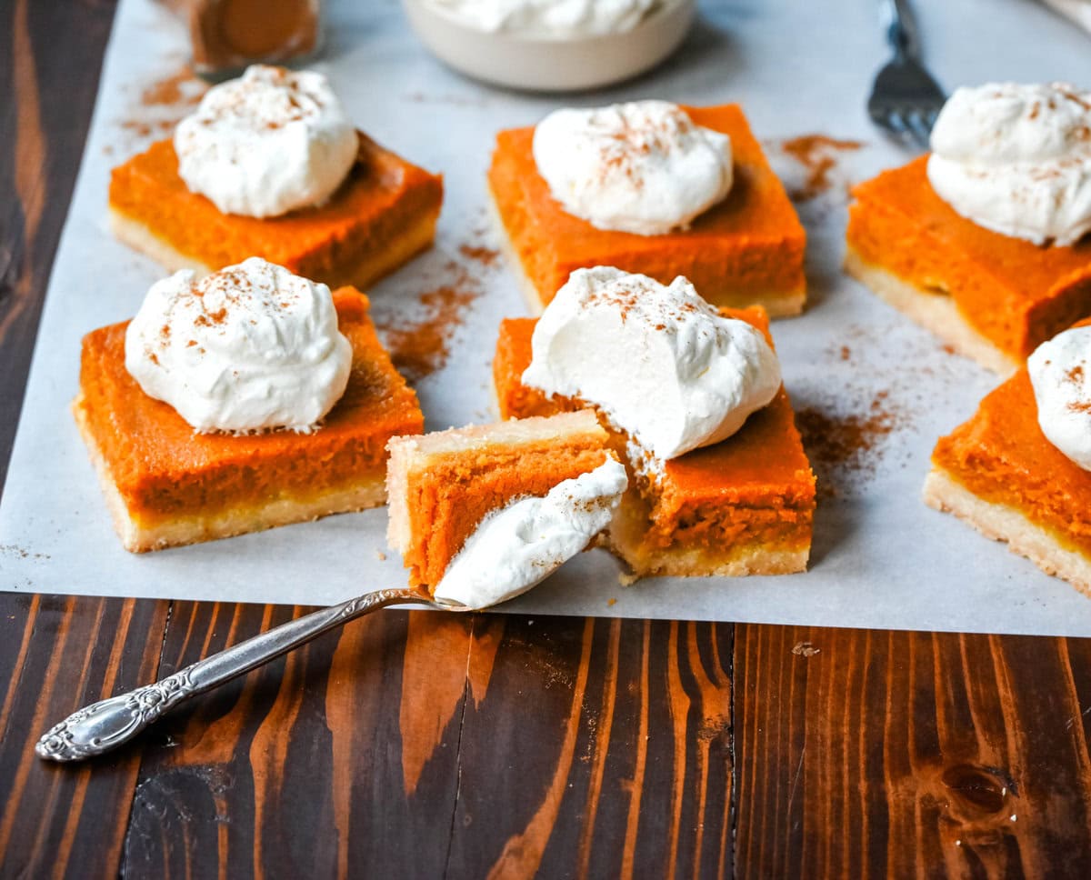 These homemade Pumpkin Pie Bars are made with a buttery shortbread crust and topped with a creamy pumpkin cream cheese filling and baked. These easy pumpkin pie bars are topped with fresh whipped cream and cut into squares for an easy alternative to pumpkin pie.