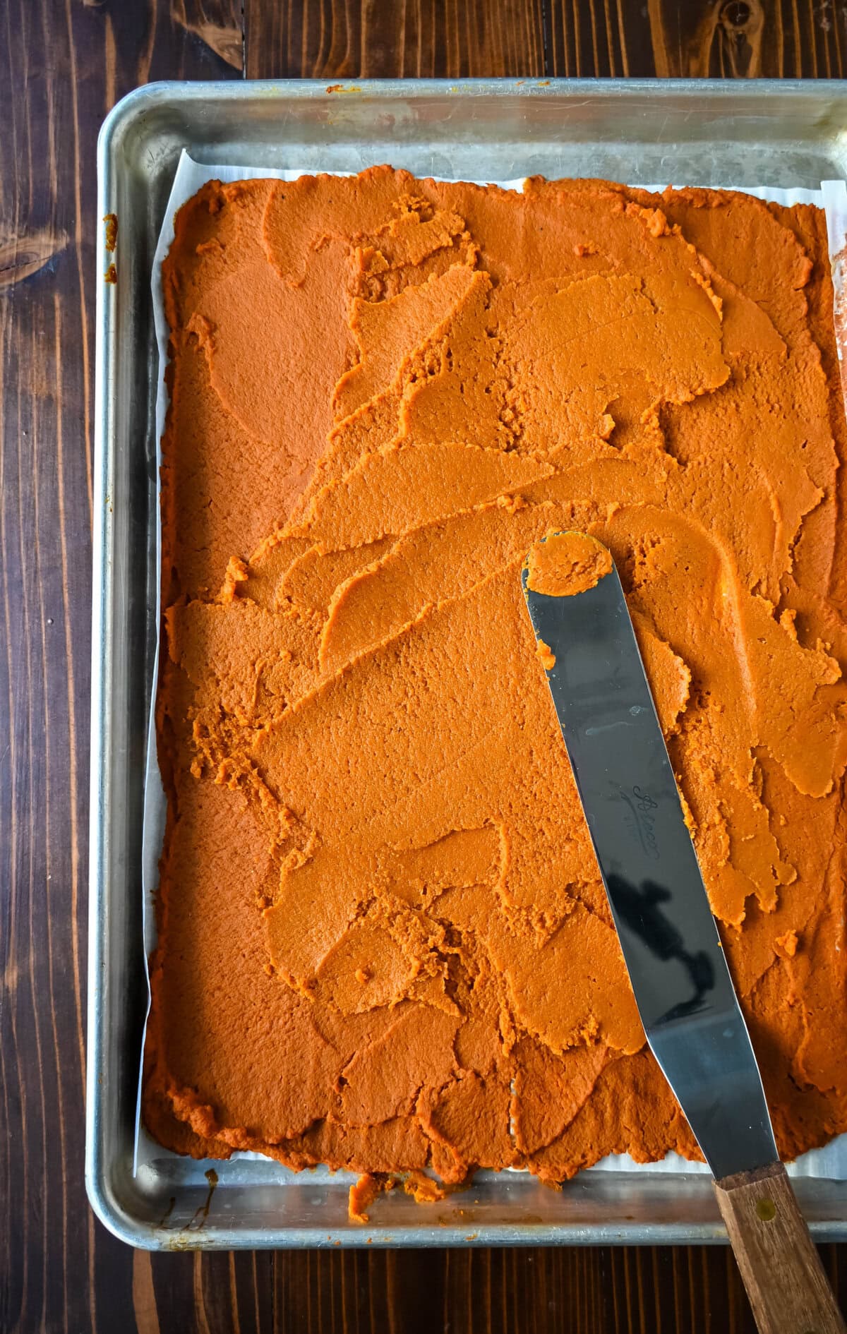 Roasted pumpkin puree on a baking sheet after roasting in the oven to prepare to make pumpkin pie