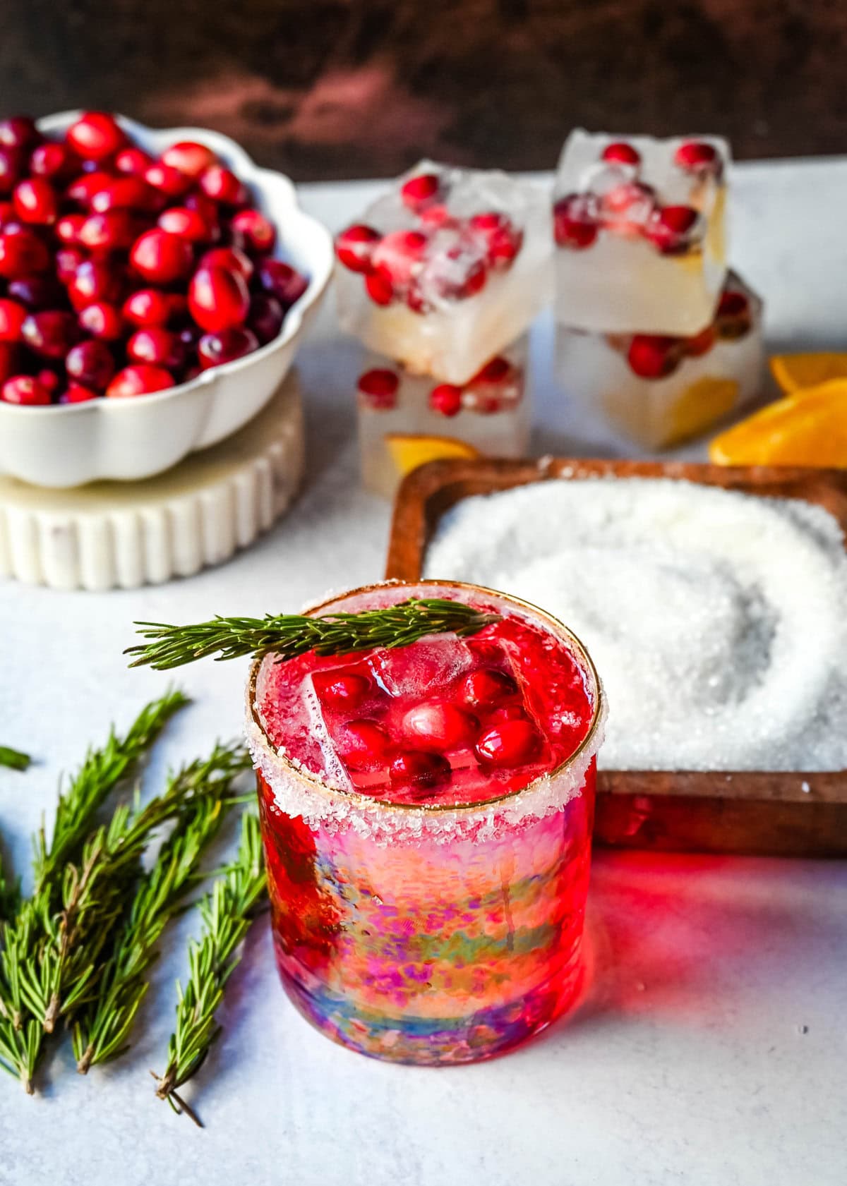 A cranberry mocktail is a gorgeous, tart, and refreshing beverage that pairs beautifully with cozy winter evenings or holiday parties. Cranberry juice, cranberry sprite, and cranberry orange infused ice cubes all in a sugar rimmed glass make this an extra special holiday mocktail recipe.