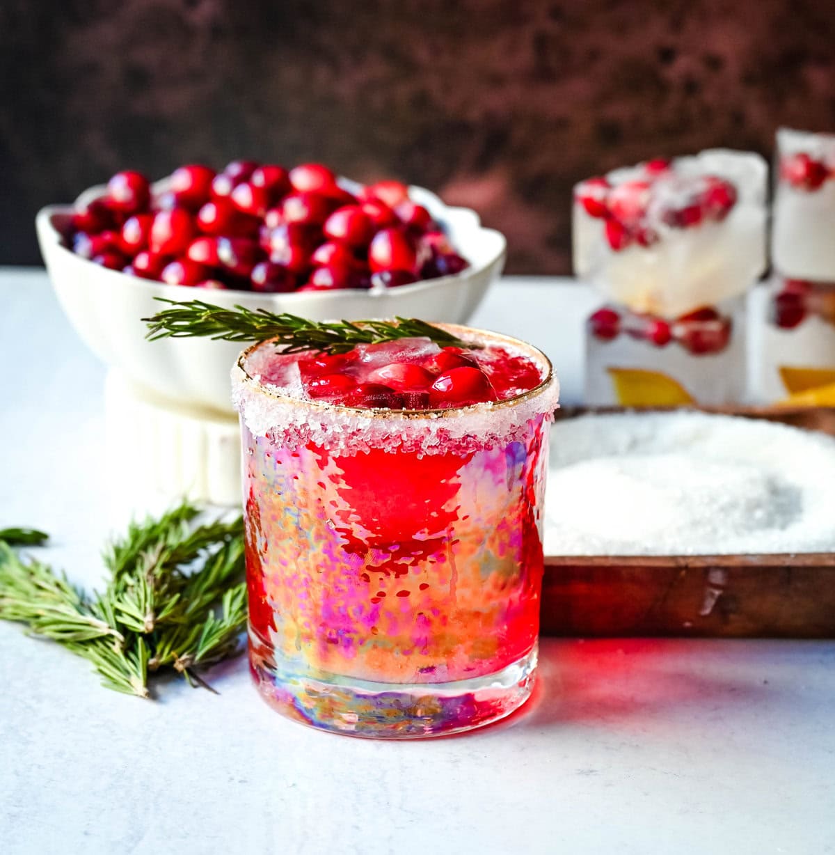 A cranberry mocktail is a gorgeous, tart, and refreshing beverage that pairs beautifully with cozy winter evenings or holiday parties. Cranberry juice, cranberry sprite, and cranberry orange infused ice cubes all in a sugar rimmed glass make this an extra special holiday mocktail recipe.