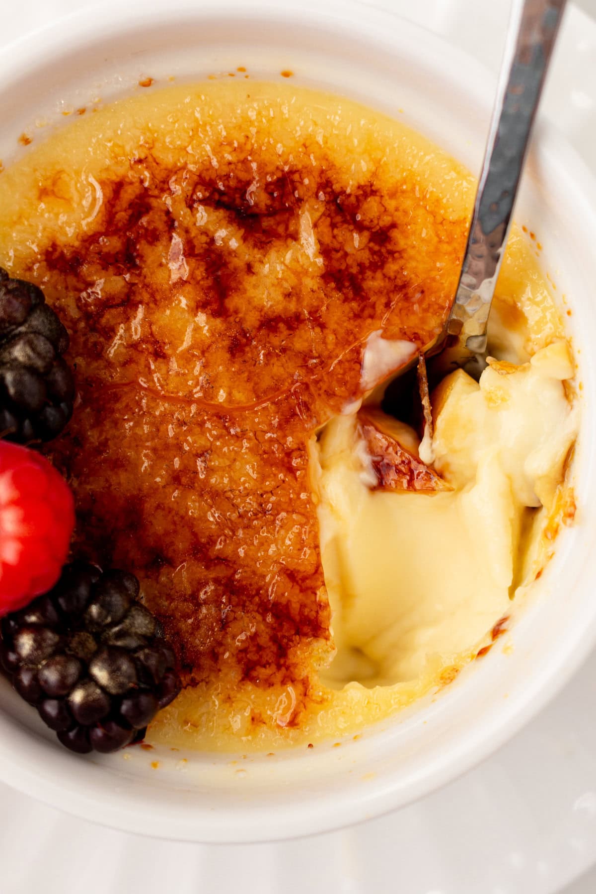 A spoon dishing out creme brulee. A creamy, silky vanilla custard topped with crisp sugar crust is one of the most popular desserts at restaurants for good reason. With its silky custard base and crackly caramelized sugar topping, it’s a showstopper that’s surprisingly easy to make at home. 