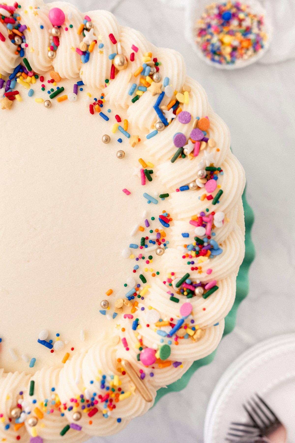 A layered funfetti or confetti cake with sprinkles. A fluffy homemade Funfetti birthday cake with rainbow sprinkles topped with a light cream cheese buttercream frosting and an array of sprinkles. This Confetti Cake recipe is the perfect birthday cake!