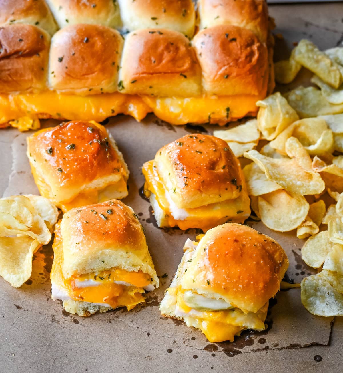 Garlic Herb Turkey and Cheddar Sliders. These Baked Turkey and Cheddar Sliders on Hawaiian Rolls with a sweet honey mustard spread and homemade garlic butter brushed on top are the perfect turkey slider recipe.  