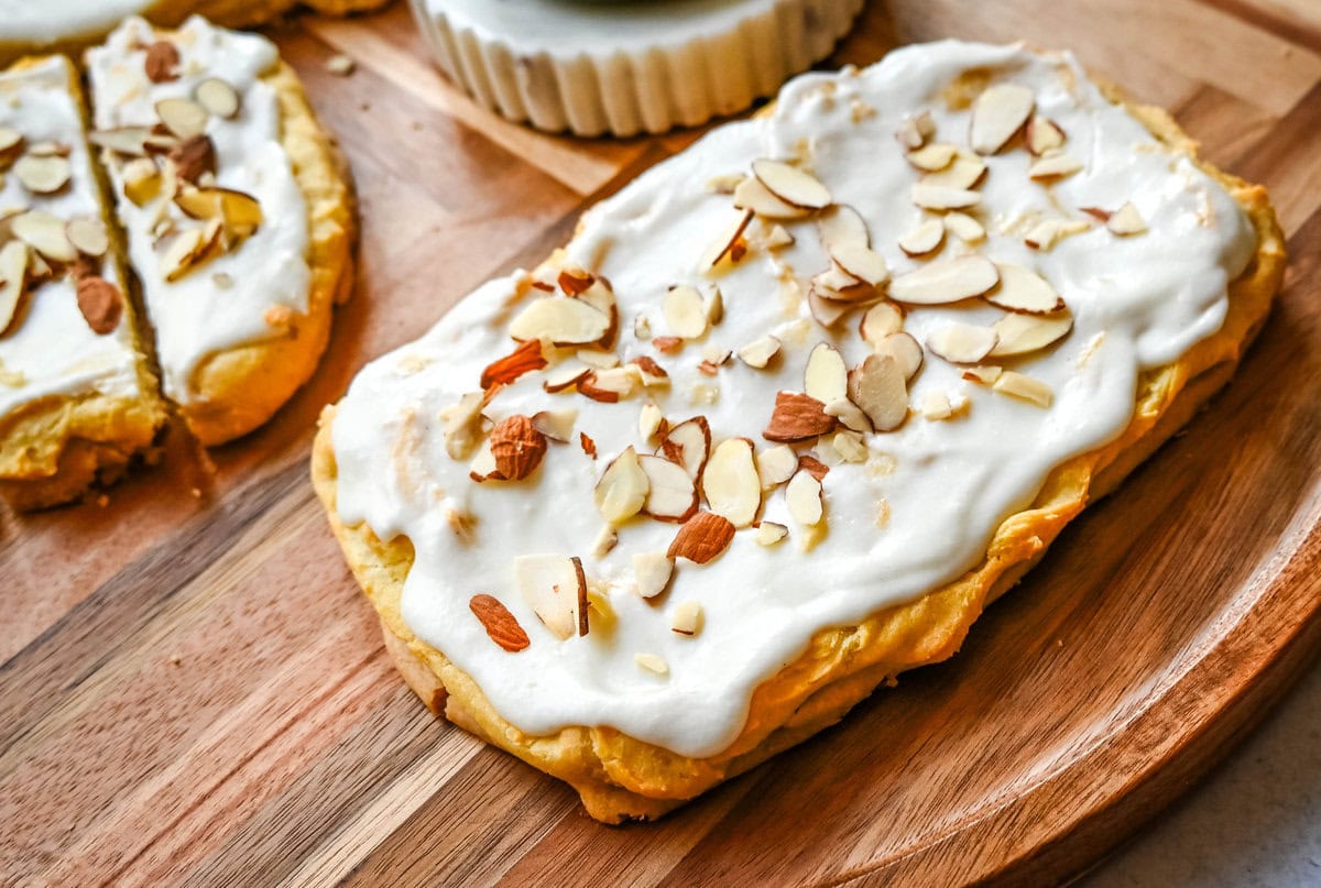 This homemade Swedish Pastry, also known as Danish Kringle, features a buttery crust, an almond filling, and topped with an almond frosting. This buttery pastry is buttery, creamy, and has just the right sweetness. A holiday tradition!