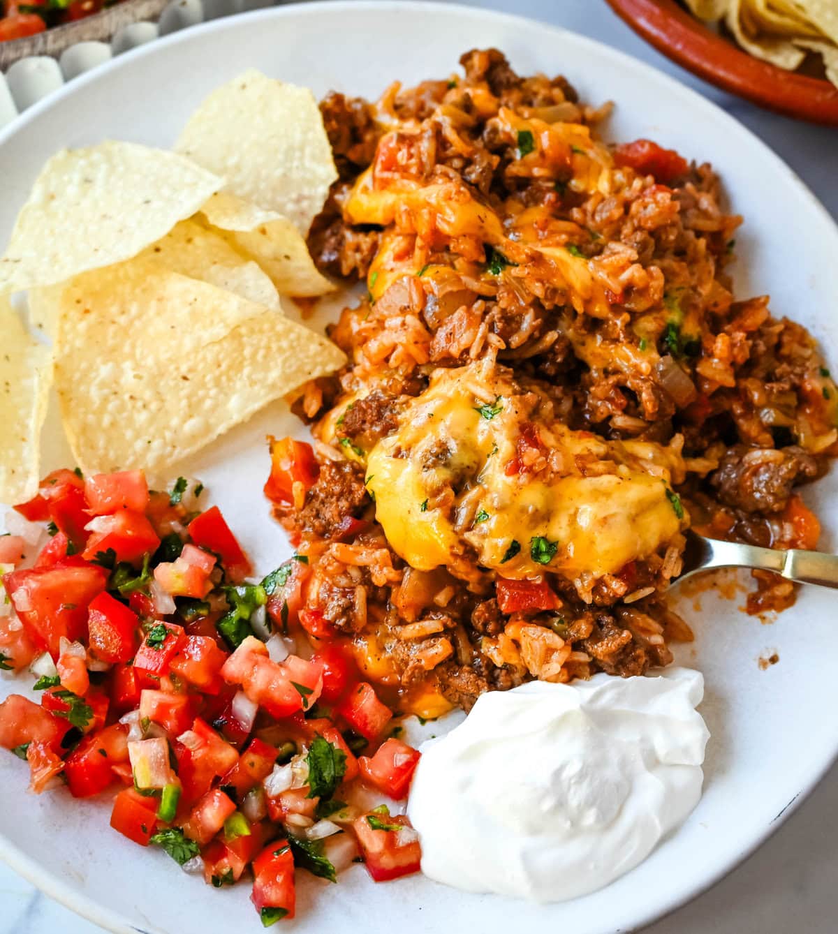 This Cheesy Taco Rice Skillet is a hearty, one-pan meal that brings all your favorite Tex-Mex flavors together in under 30 minutes. This Mexican Taco Skillet is loaded with seasoned ground beef, uncooked rice, and diced tomatoes—then simmered in a savory blend of beef broth and spices until perfectly tender and topped with melted cheese. A total crowd-pleaser for families and busy weeknights.  