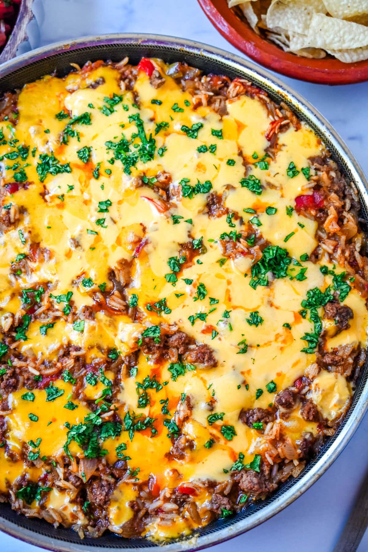 This Cheesy Taco Rice Skillet is a hearty, one-pan meal that brings all your favorite Tex-Mex flavors together in under 30 minutes. This Mexican Taco Skillet is loaded with seasoned ground beef, uncooked rice, and diced tomatoes—then simmered in a savory blend of beef broth and spices until perfectly tender and topped with melted cheese. A total crowd-pleaser for families and busy weeknights.