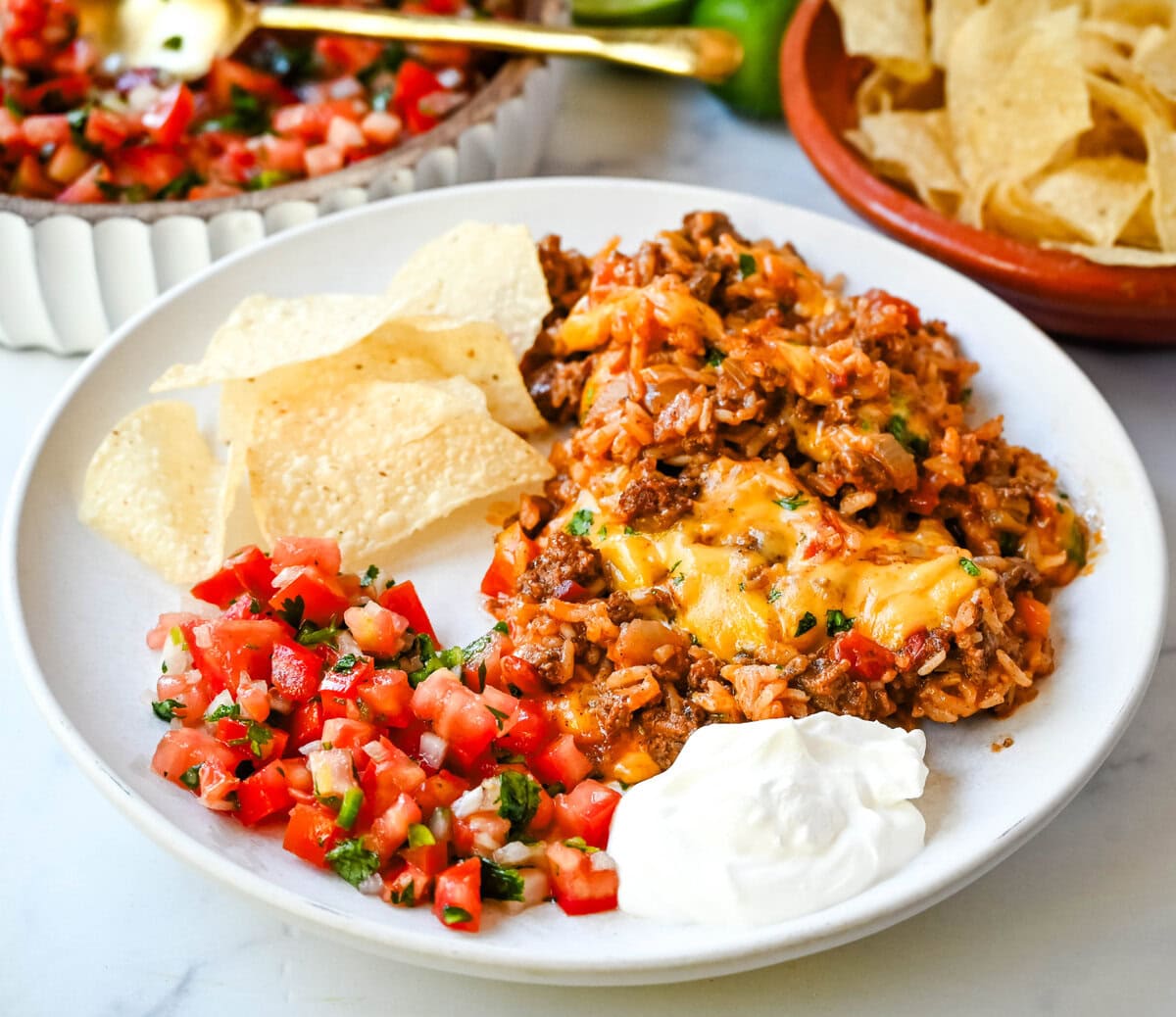 This Cheesy Taco Rice Skillet is a hearty, one-pan meal that brings all your favorite Tex-Mex flavors together in under 30 minutes. This Mexican Taco Skillet is loaded with seasoned ground beef, uncooked rice, and diced tomatoes—then simmered in a savory blend of beef broth and spices until perfectly tender and topped with melted cheese. A total crowd-pleaser for families and busy weeknights.  