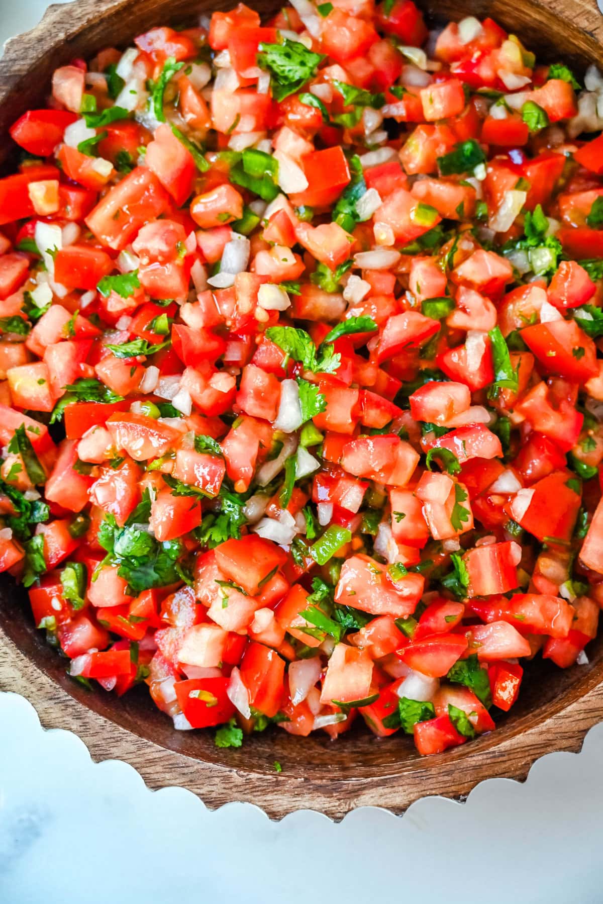 How to make fresh homemade pico de gallo made with the freshest ingredients -- fresh tomatoes, onion, cilantro, jalapeños, and lime juice. It is delicious on tacos, burritos, grilled meats, or as a simple fresh salsa with tortilla chips. It is super easy to whip up and is made with only six ingredients. 