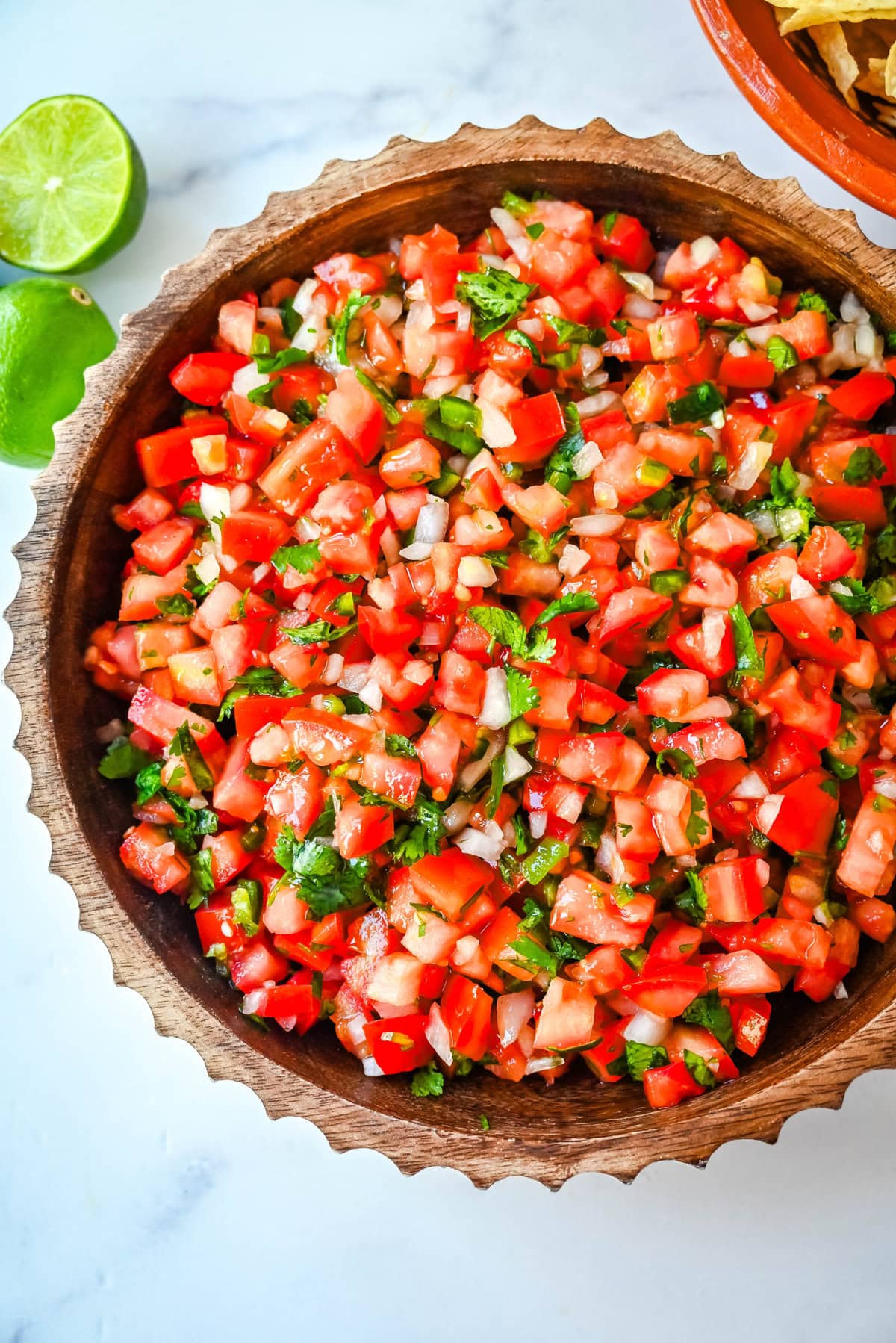 How to make fresh homemade pico de gallo made with the freshest ingredients -- fresh tomatoes, onion, cilantro, jalapeños, and lime juice. It is delicious on tacos, burritos, grilled meats, or as a simple fresh salsa with tortilla chips. It is super easy to whip up and is made with only six ingredients. 