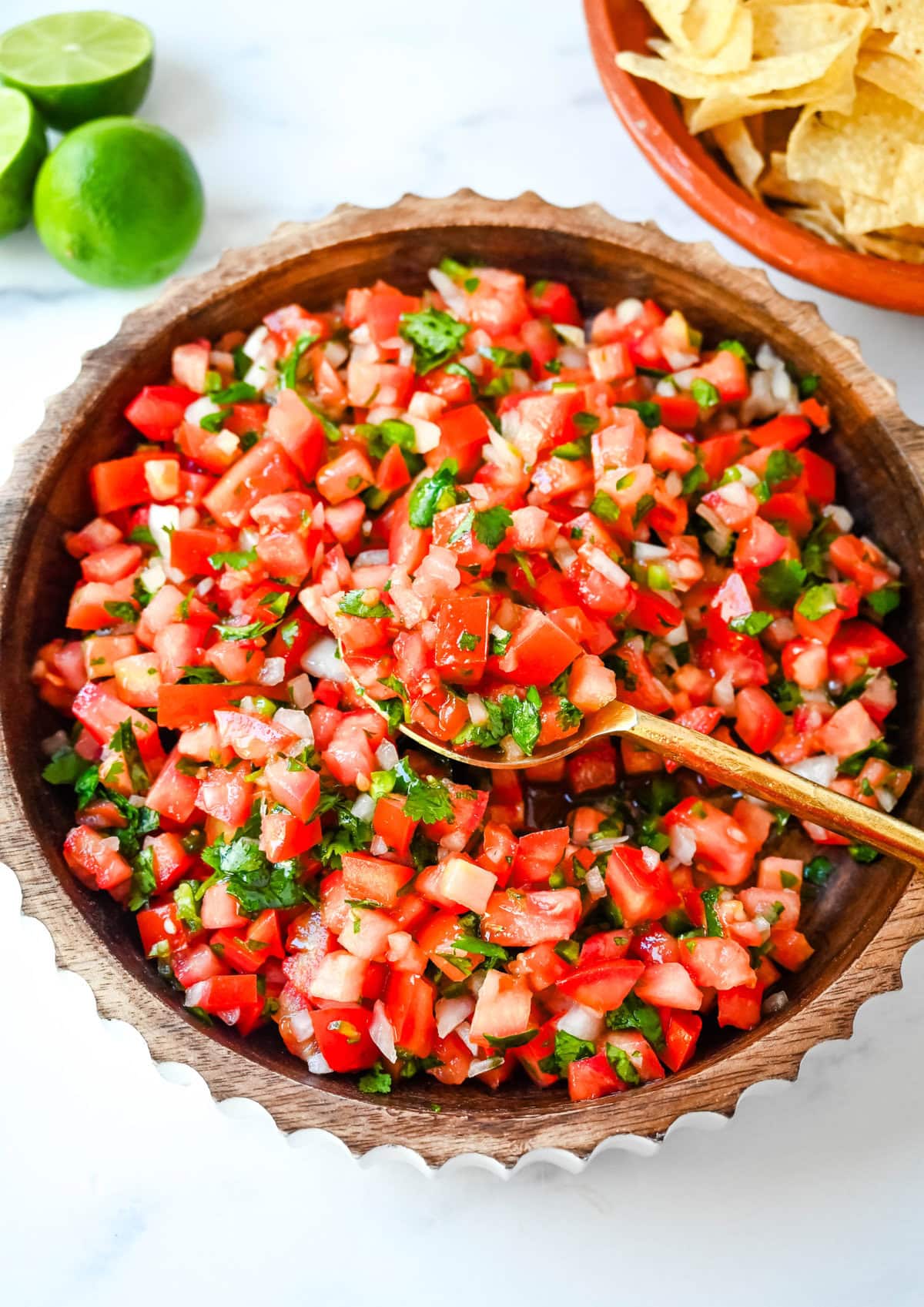 How to make fresh homemade pico de gallo made with the freshest ingredients -- fresh tomatoes, onion, cilantro, jalapeños, and lime juice. It is delicious on tacos, burritos, grilled meats, or as a simple fresh salsa with tortilla chips. It is super easy to whip up and is made with only six ingredients. 